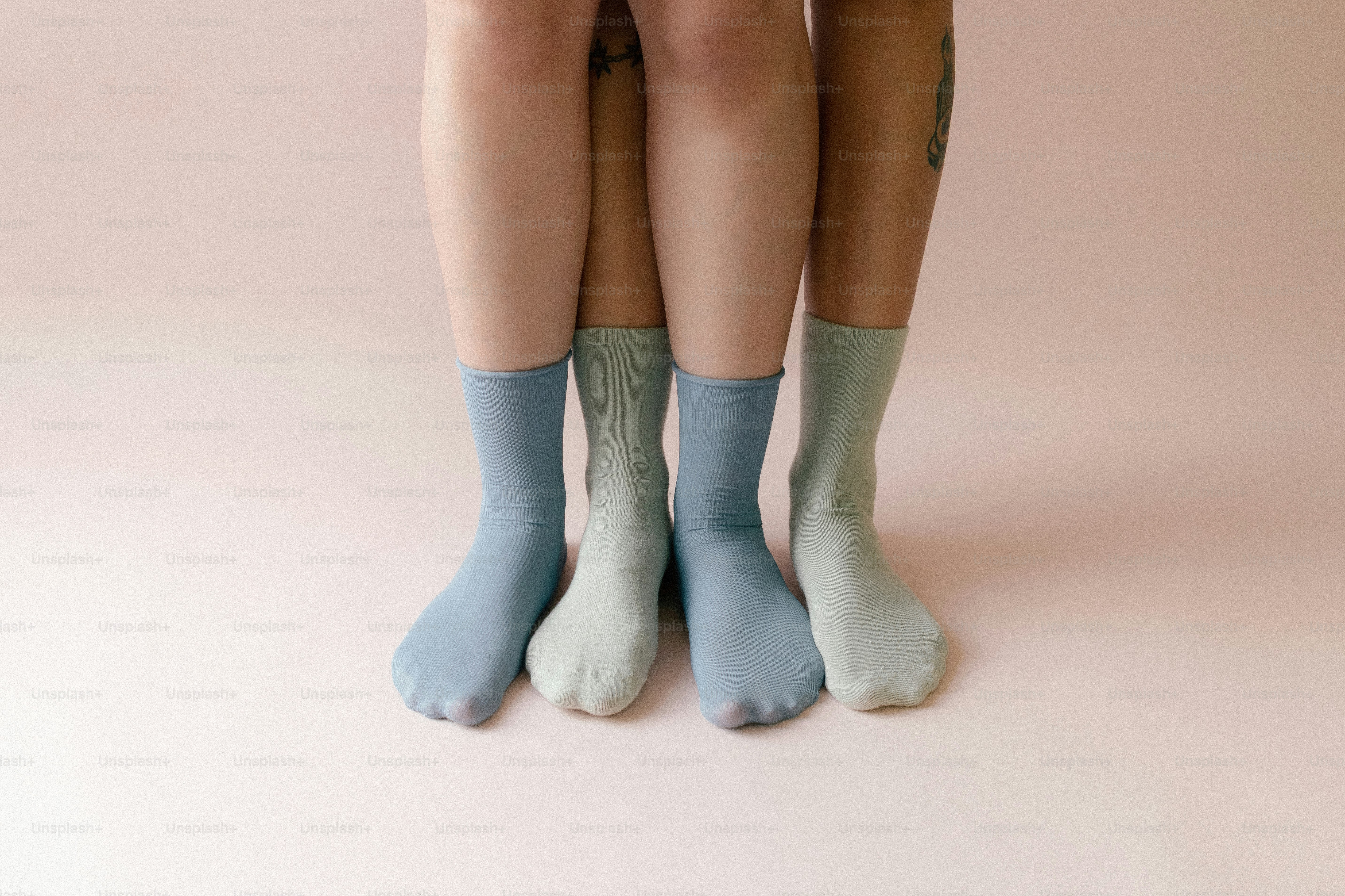 Zwei Paare bunter Socken auf rosa Hintergrund