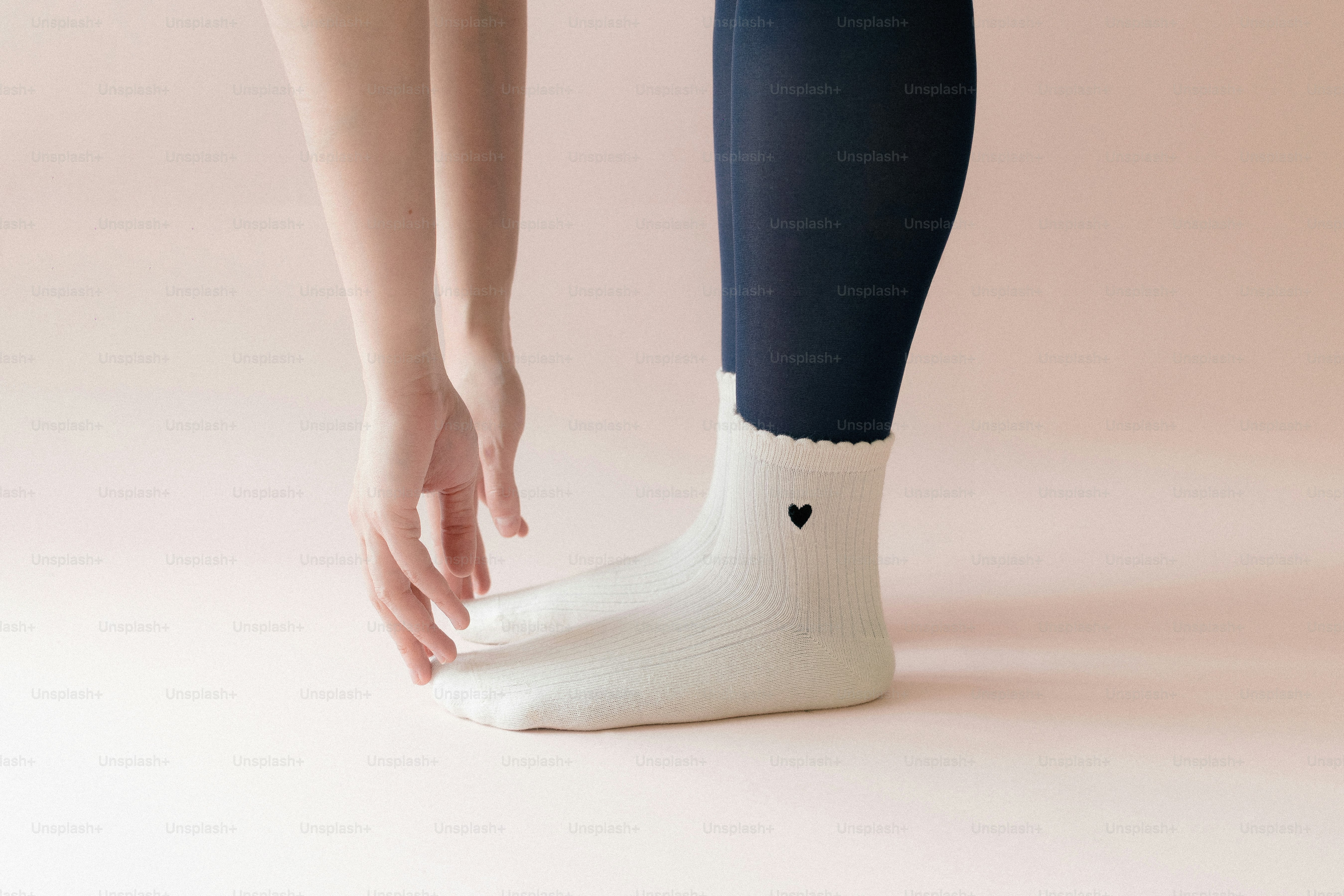 Das Bein einer Person trägt eine weiße Socke mit einem Herzen