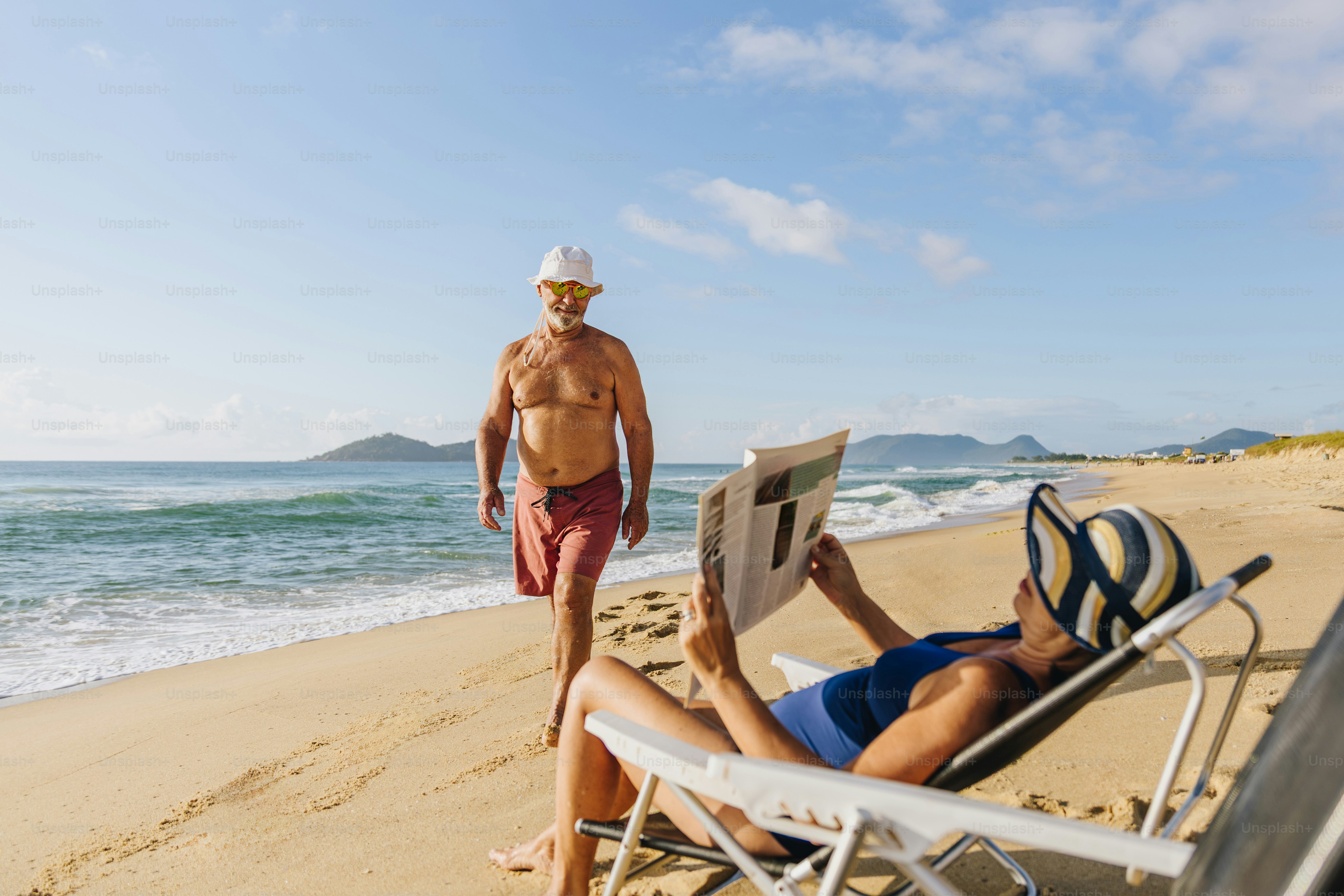 Couple relaxing on a sunny beach by the ocean.