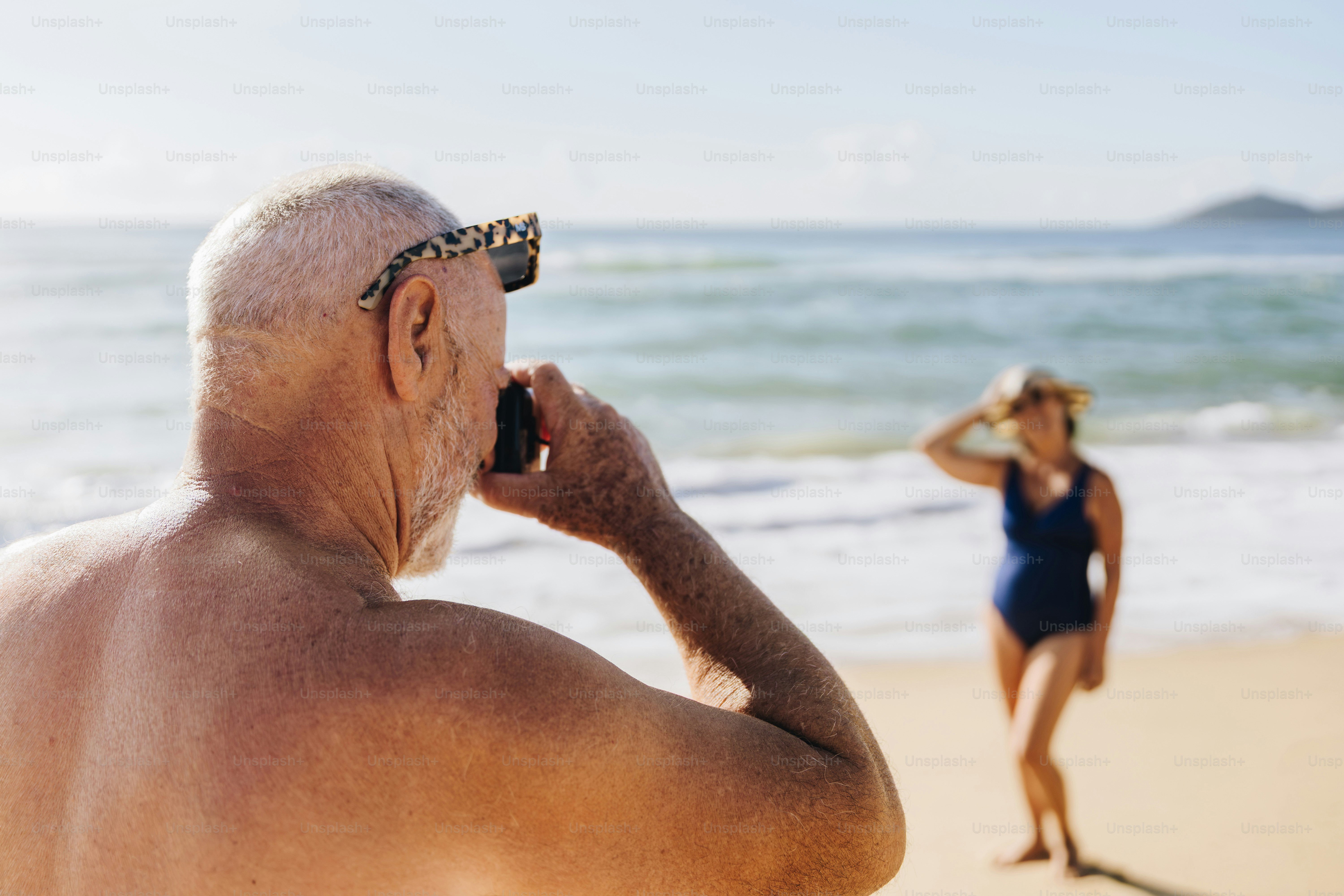 Man taking picture of woman on beach