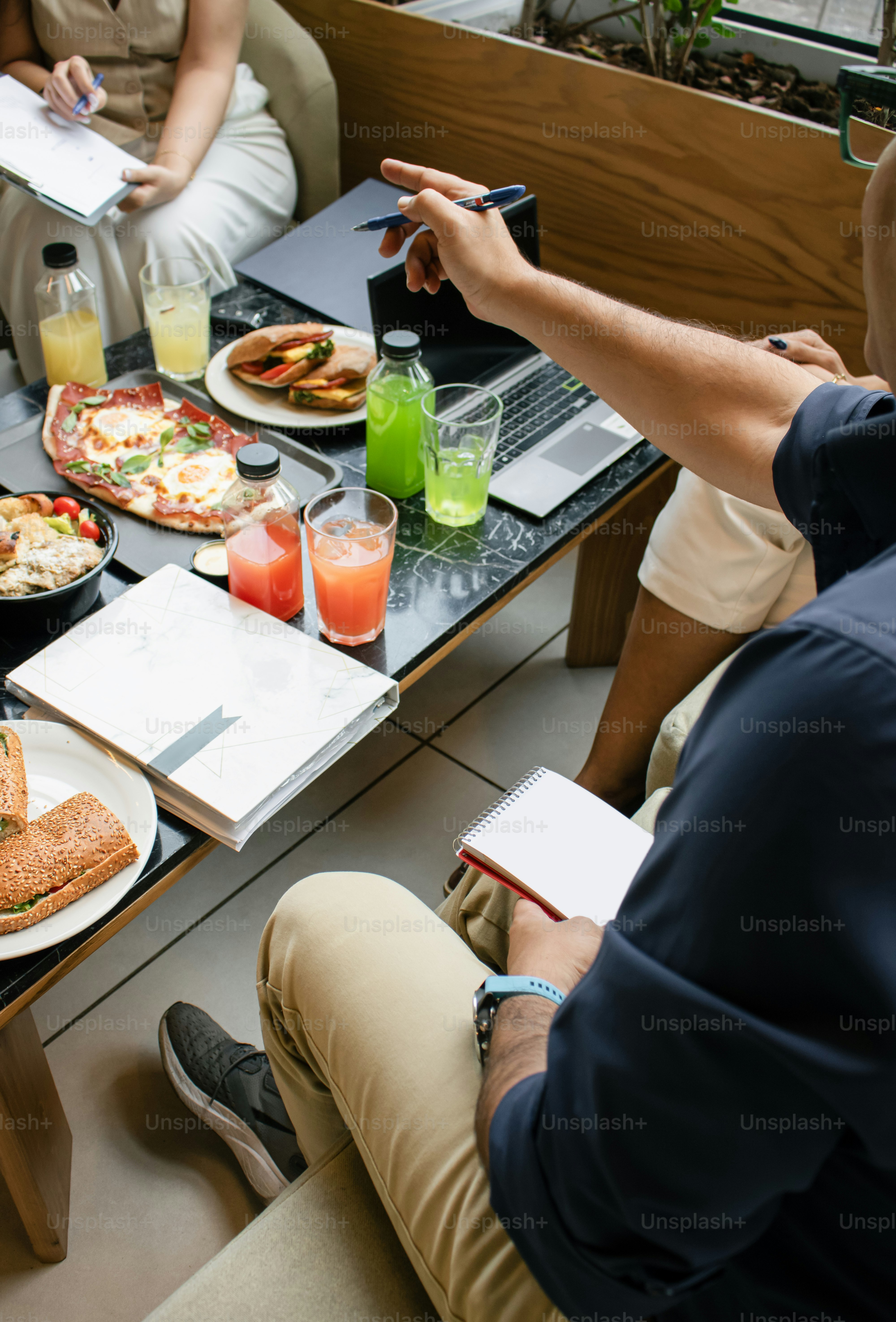 Die Leute versammelten sich um einen Tisch mit Essen und Laptops.