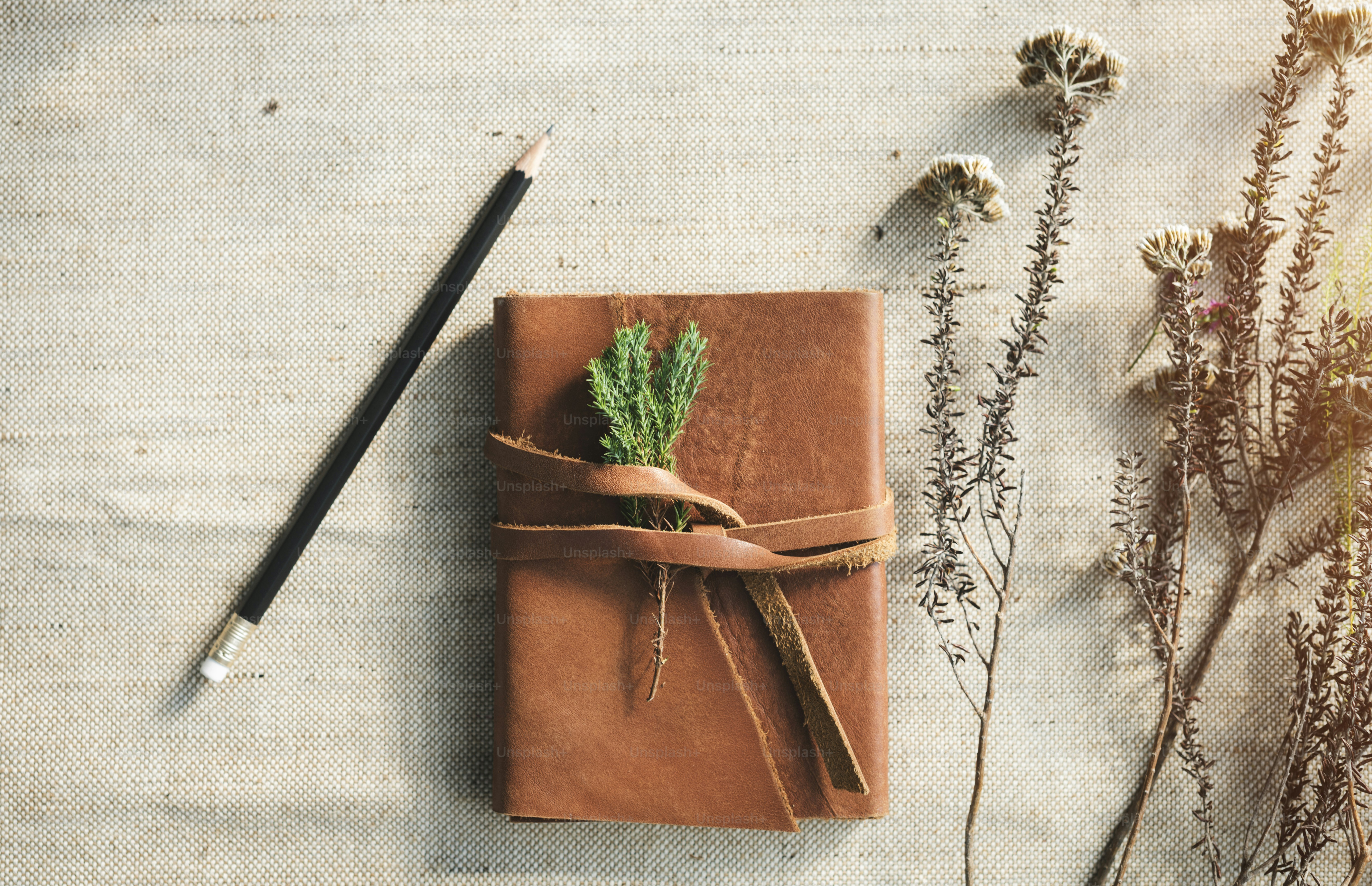 Leather personal journal with flowers on desk