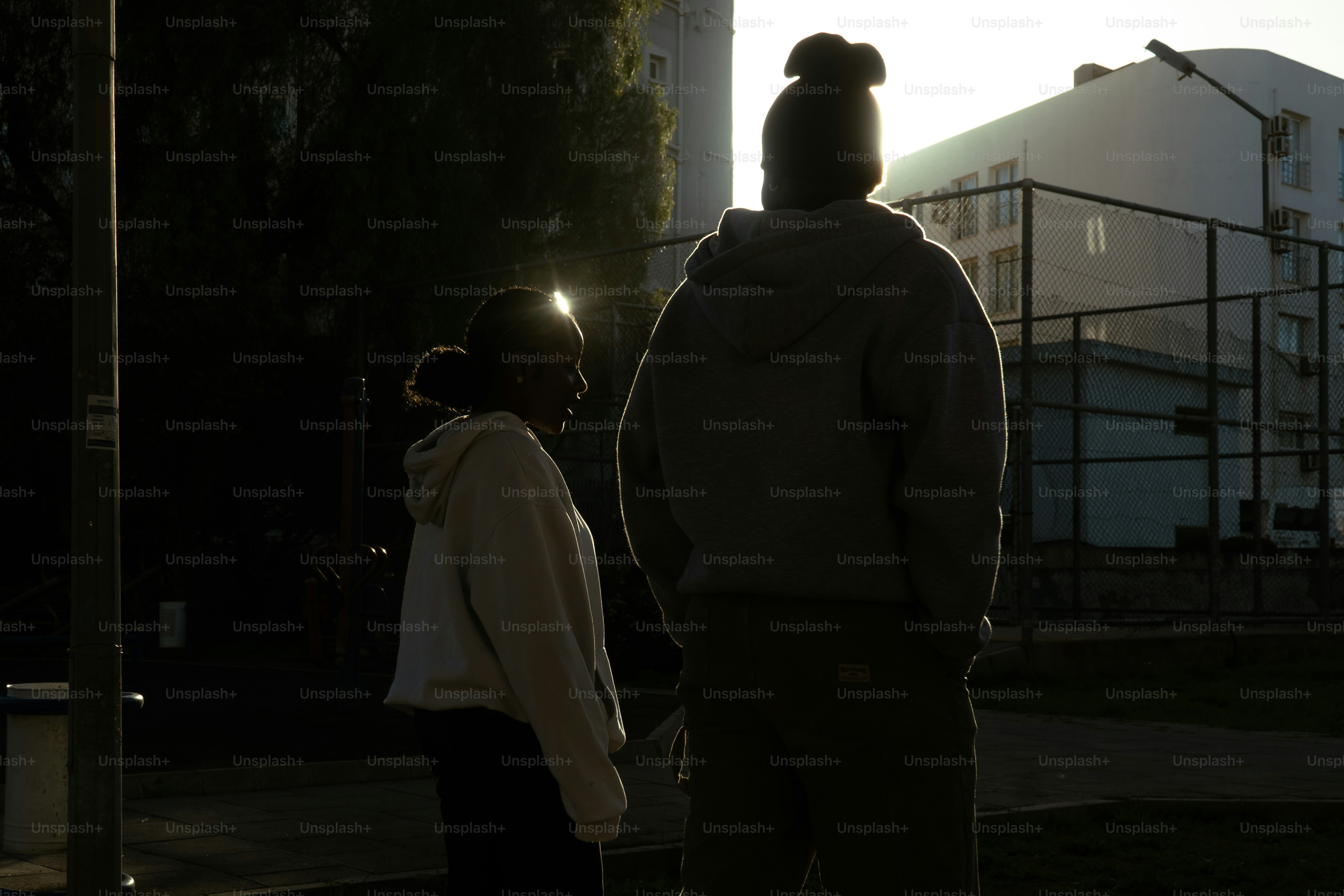 Dos personas se siluetan contra el sol poniente.