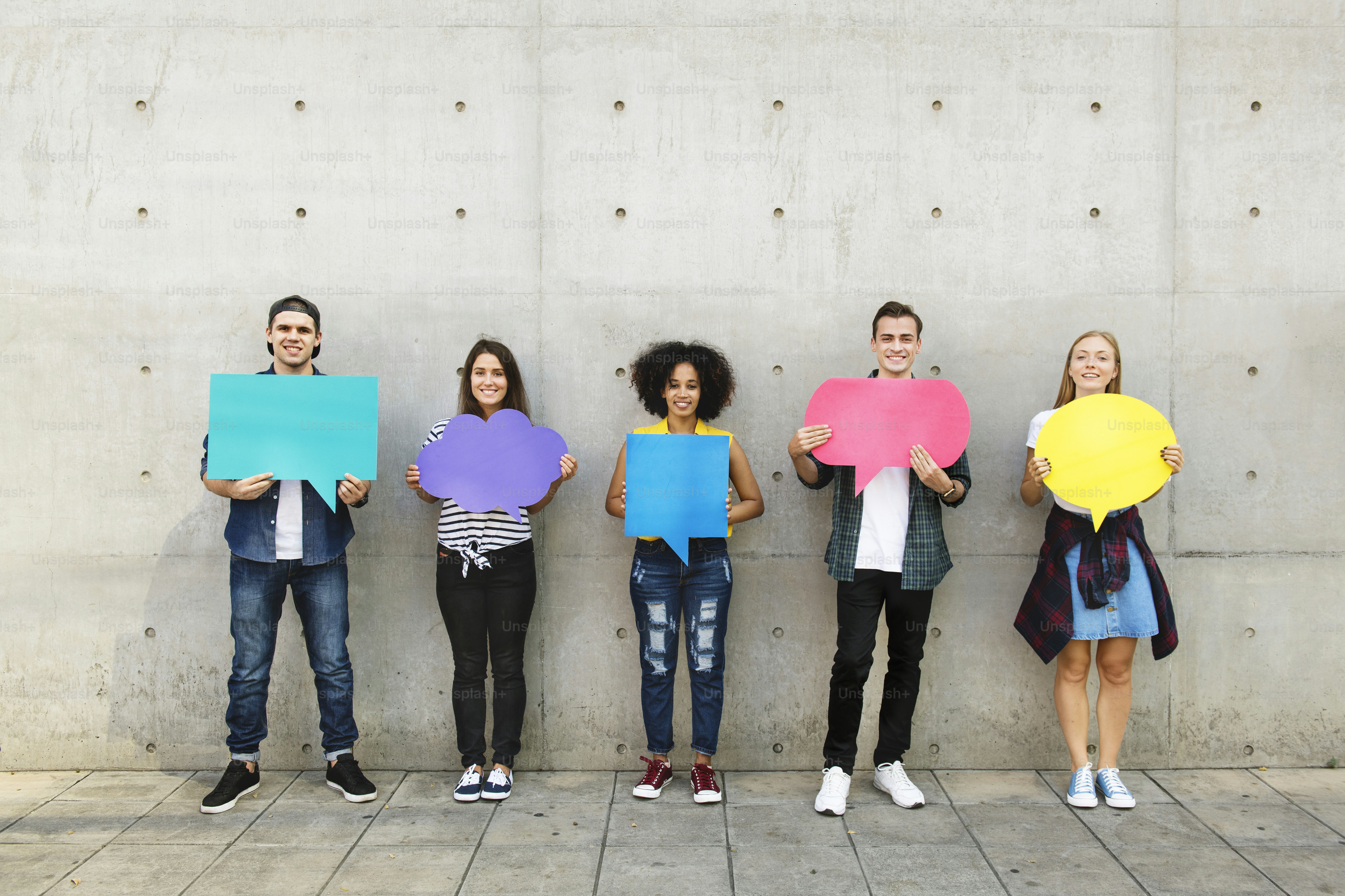 Group of young adults outdoors holding empty placard copy-space thought bubbles