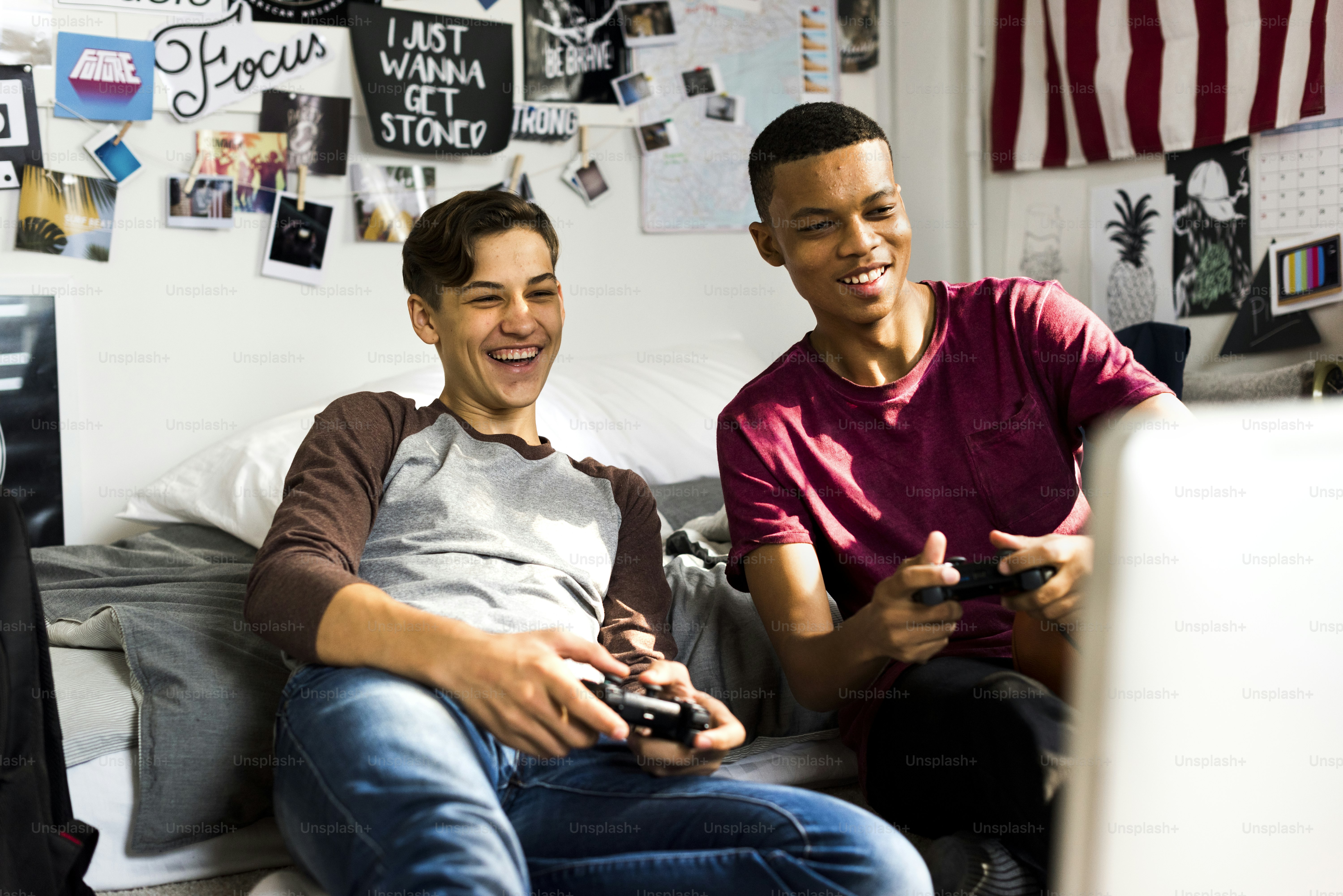 Teenage boys hanging out in a bedroom playing video games together ***These documents are our own generic designs. They do not infringe on any copyrighted designs.