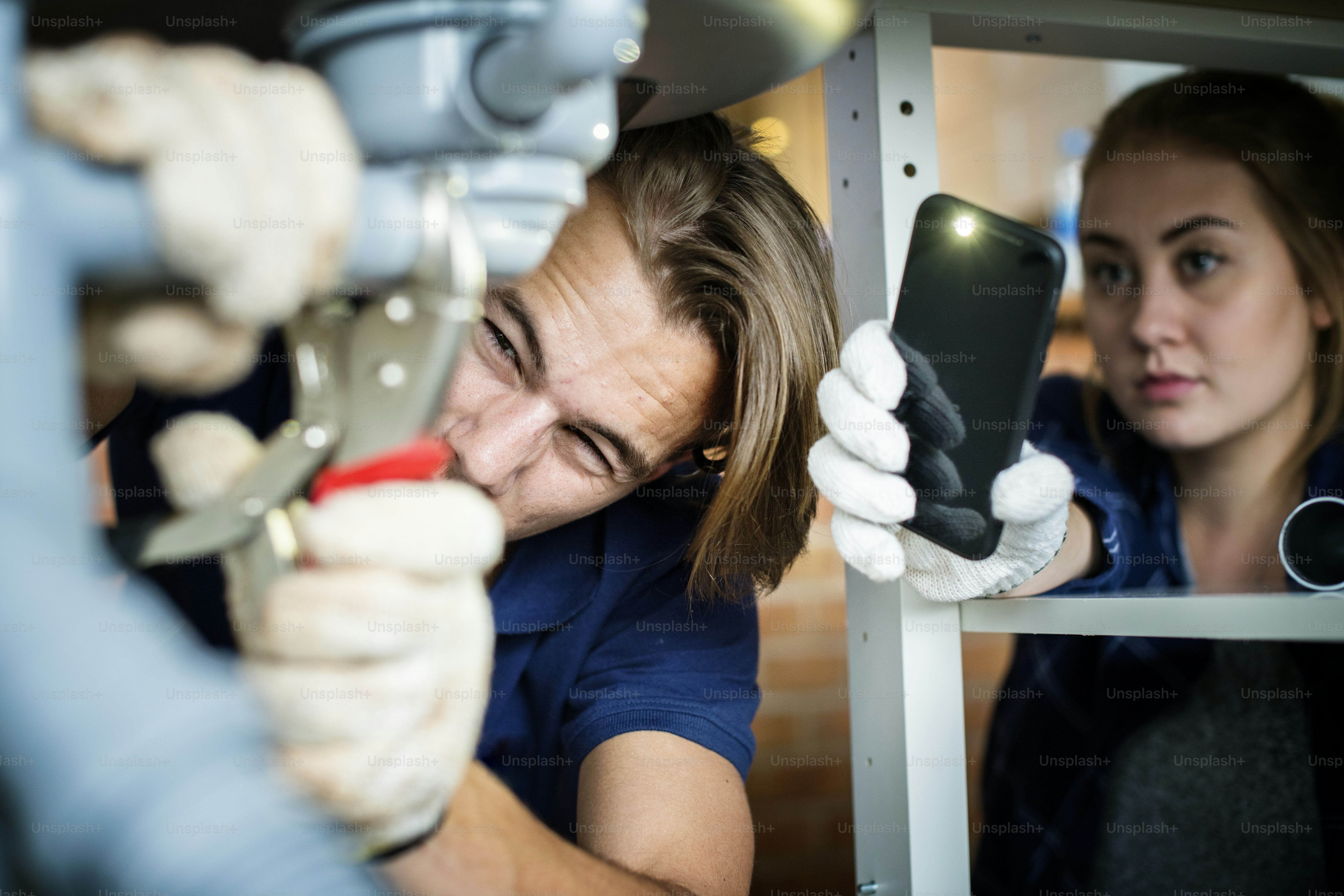 Paar repariert die Küchenspüle