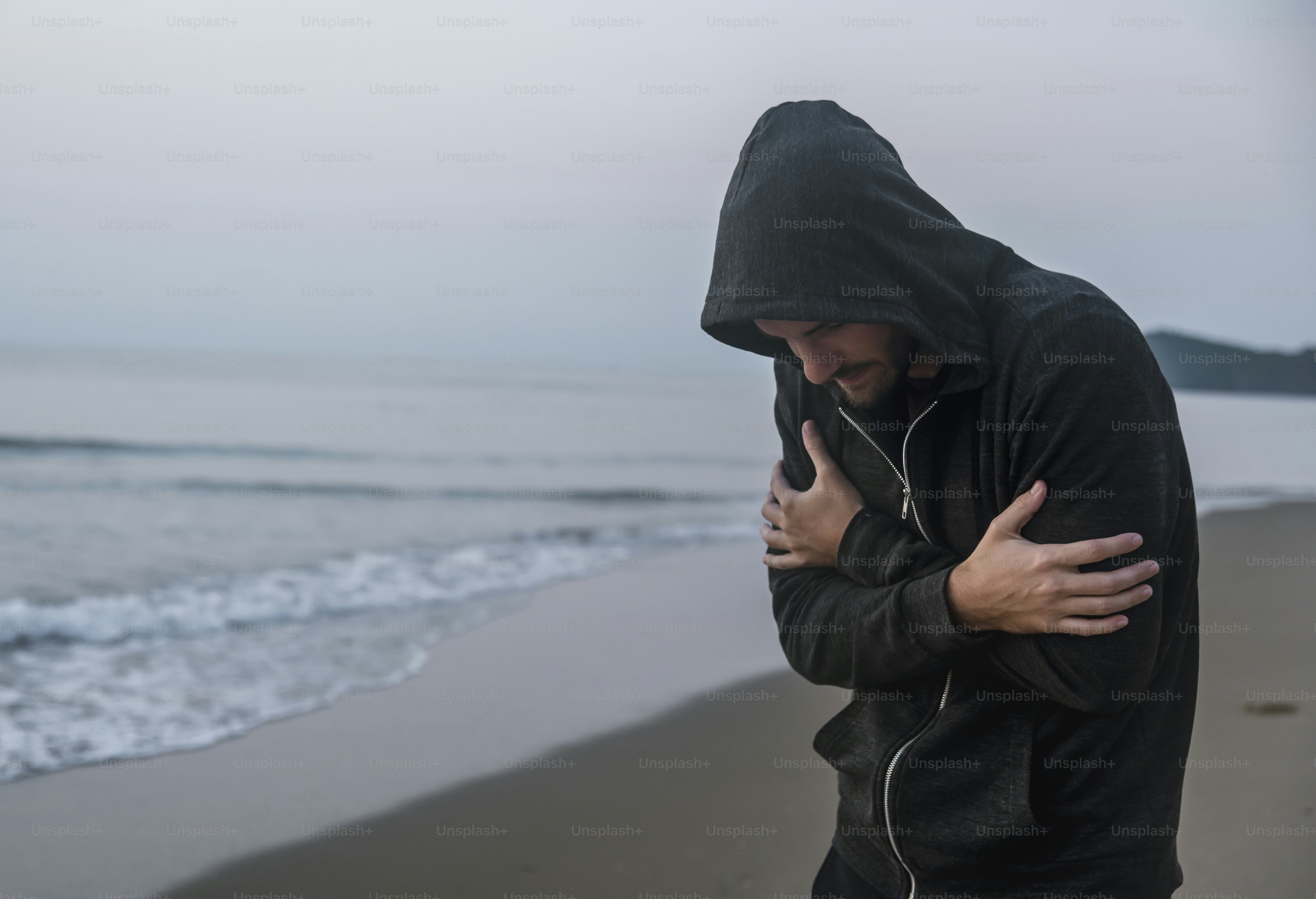 Uomo caucasico che cammina da solo sulla spiaggia