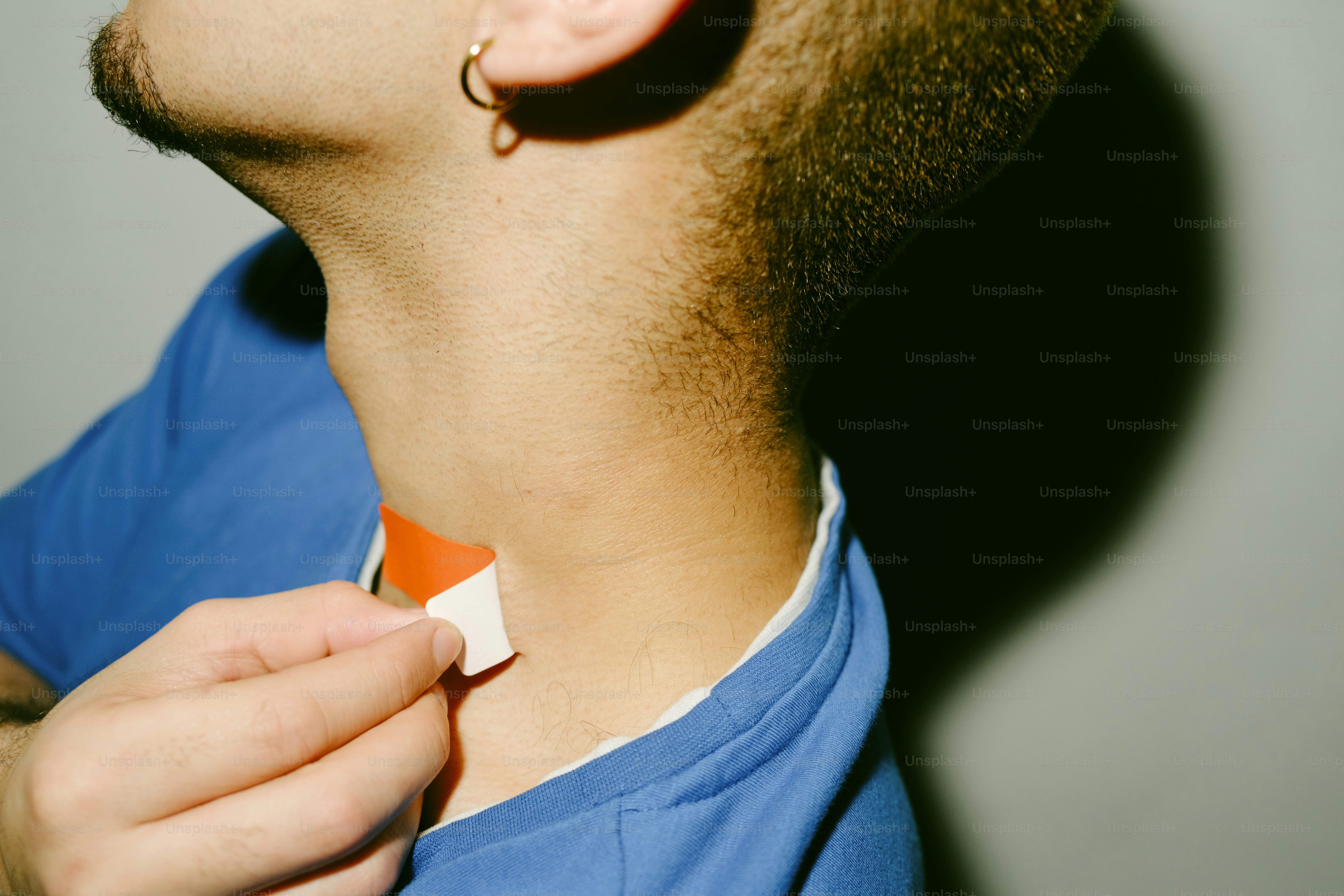 Uma pessoa ajustando uma etiqueta branca na camisa azul.