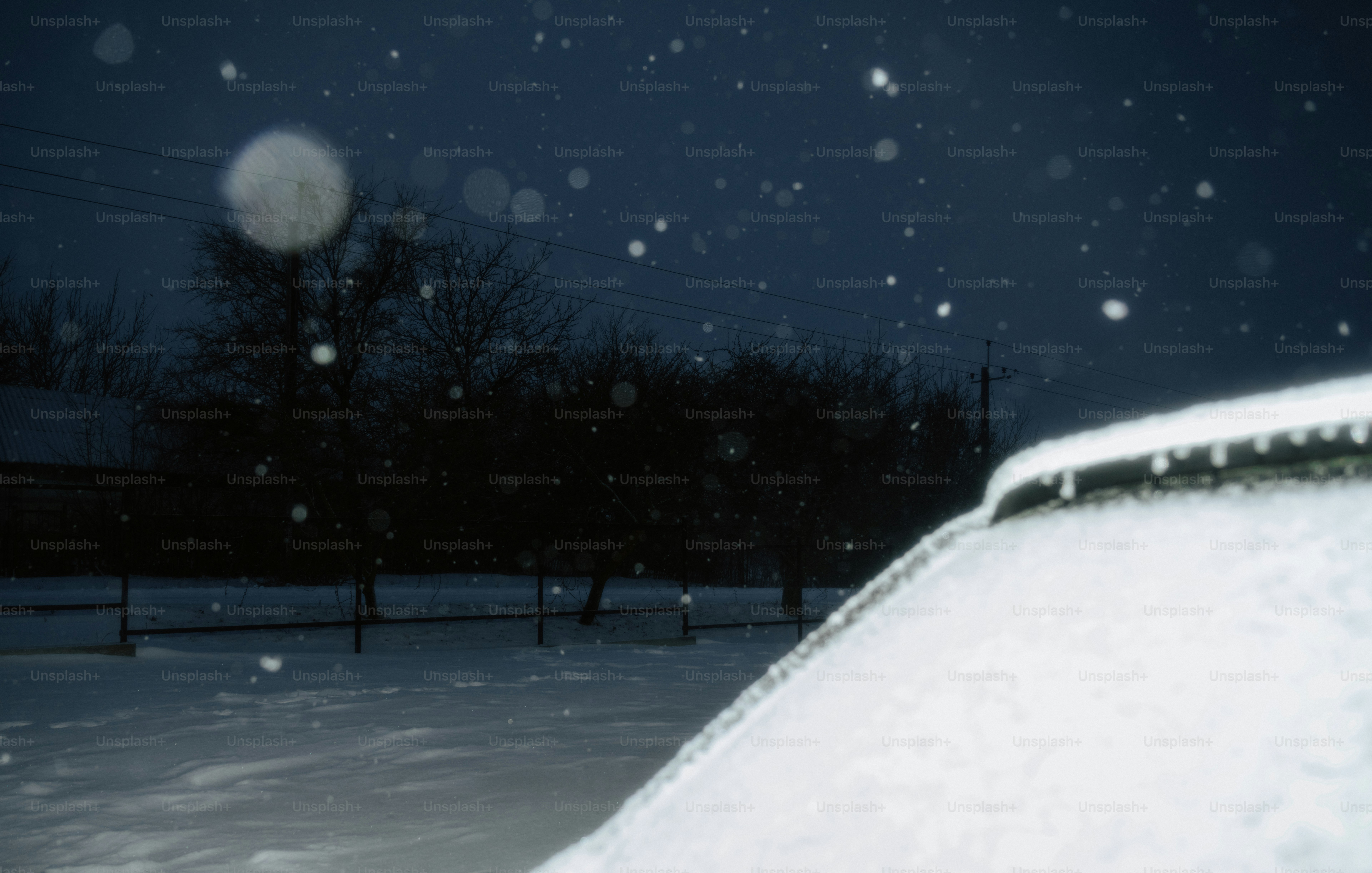 Snow falling at night over a car
