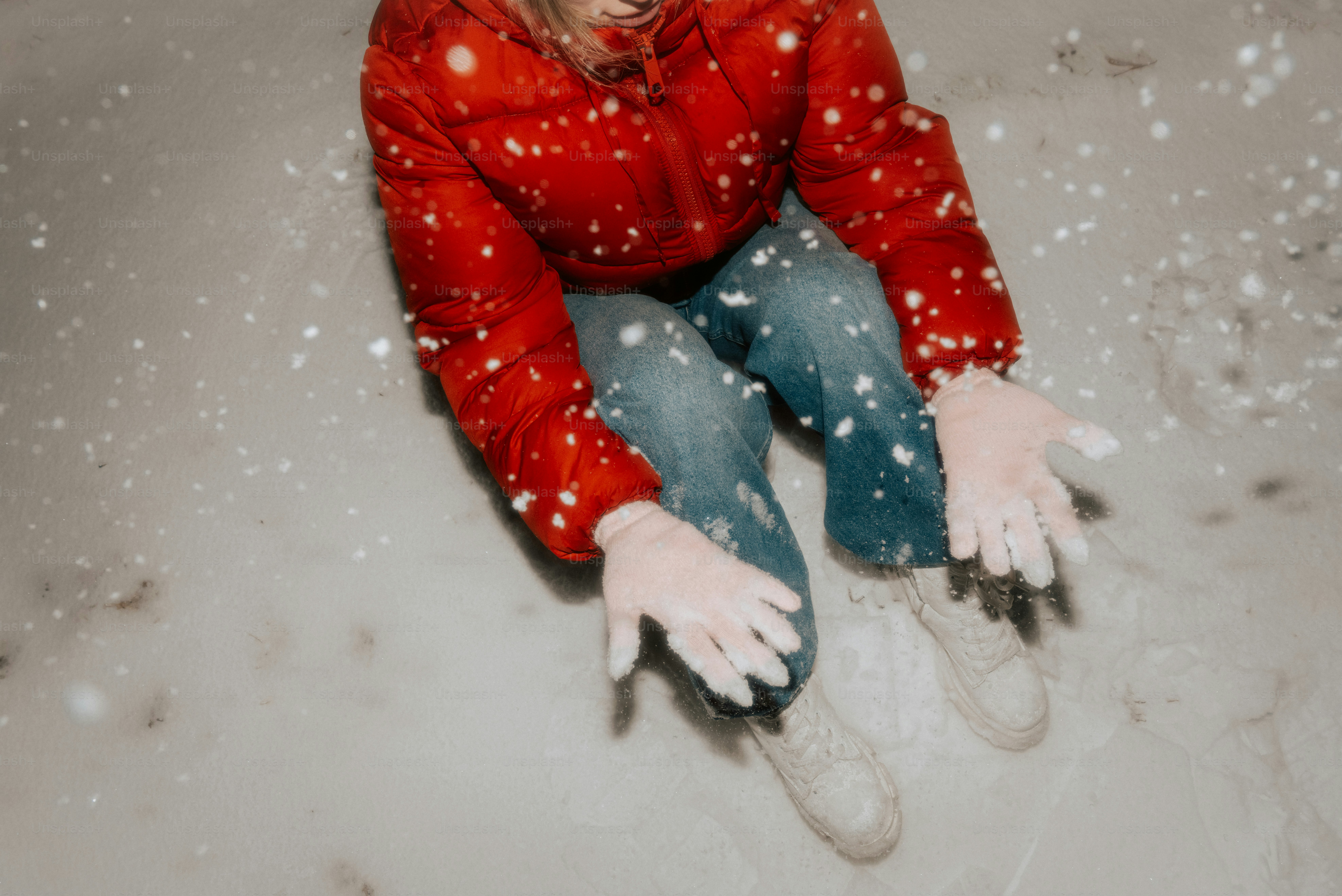 Woman in red jacket sits in snow