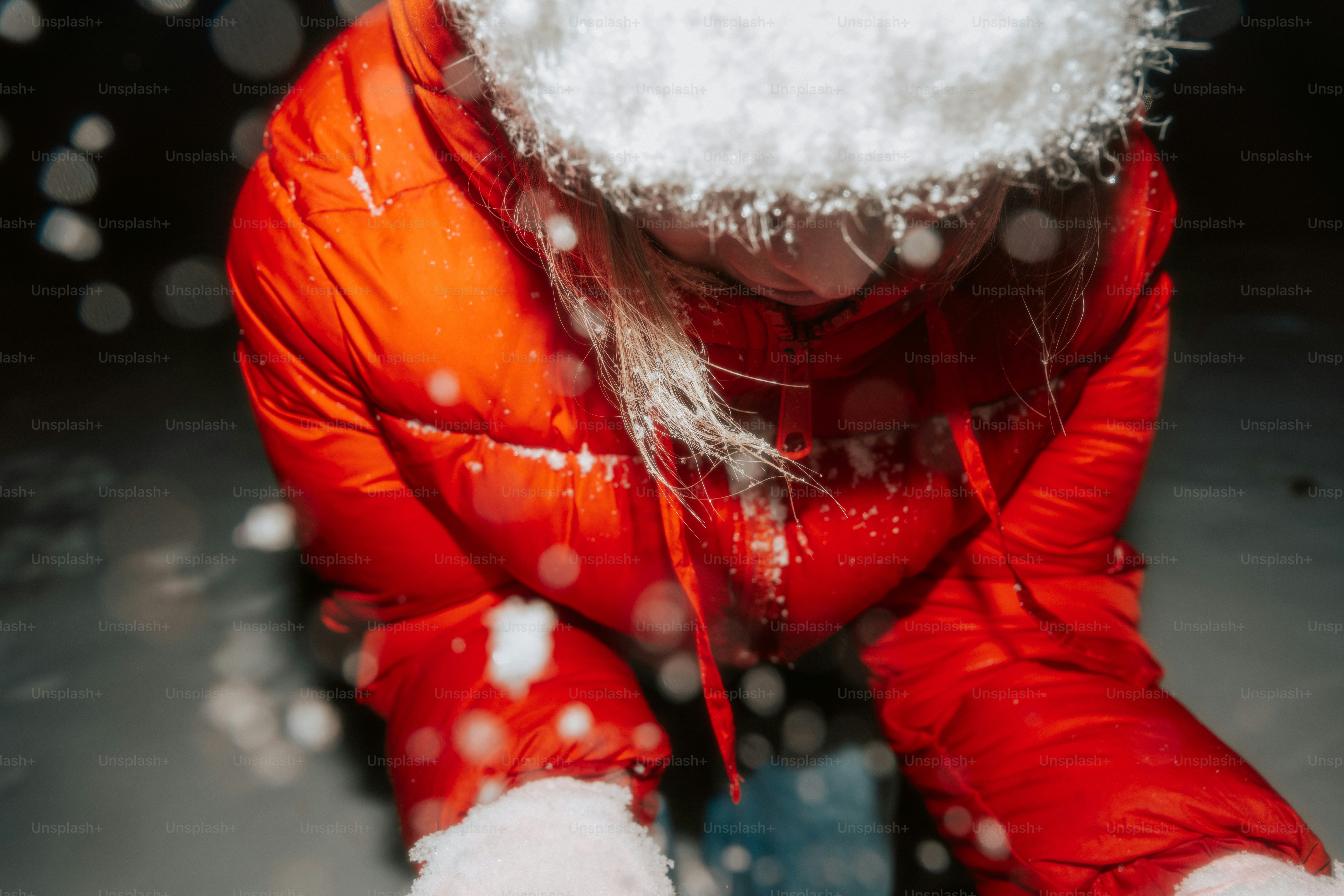 A person in a red jacket playing in snow