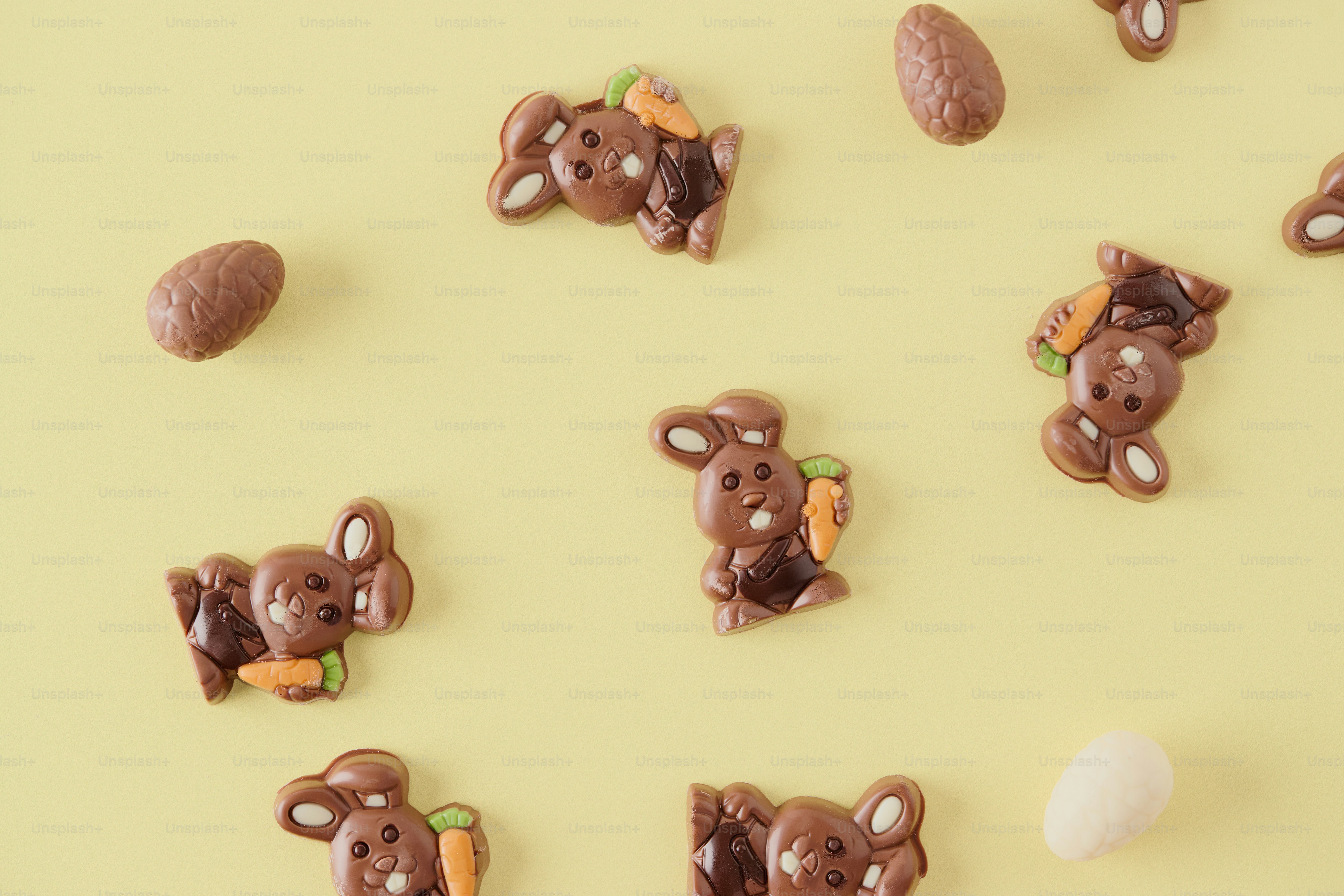 Chocolate bunnies and eggs scattered on a yellow background