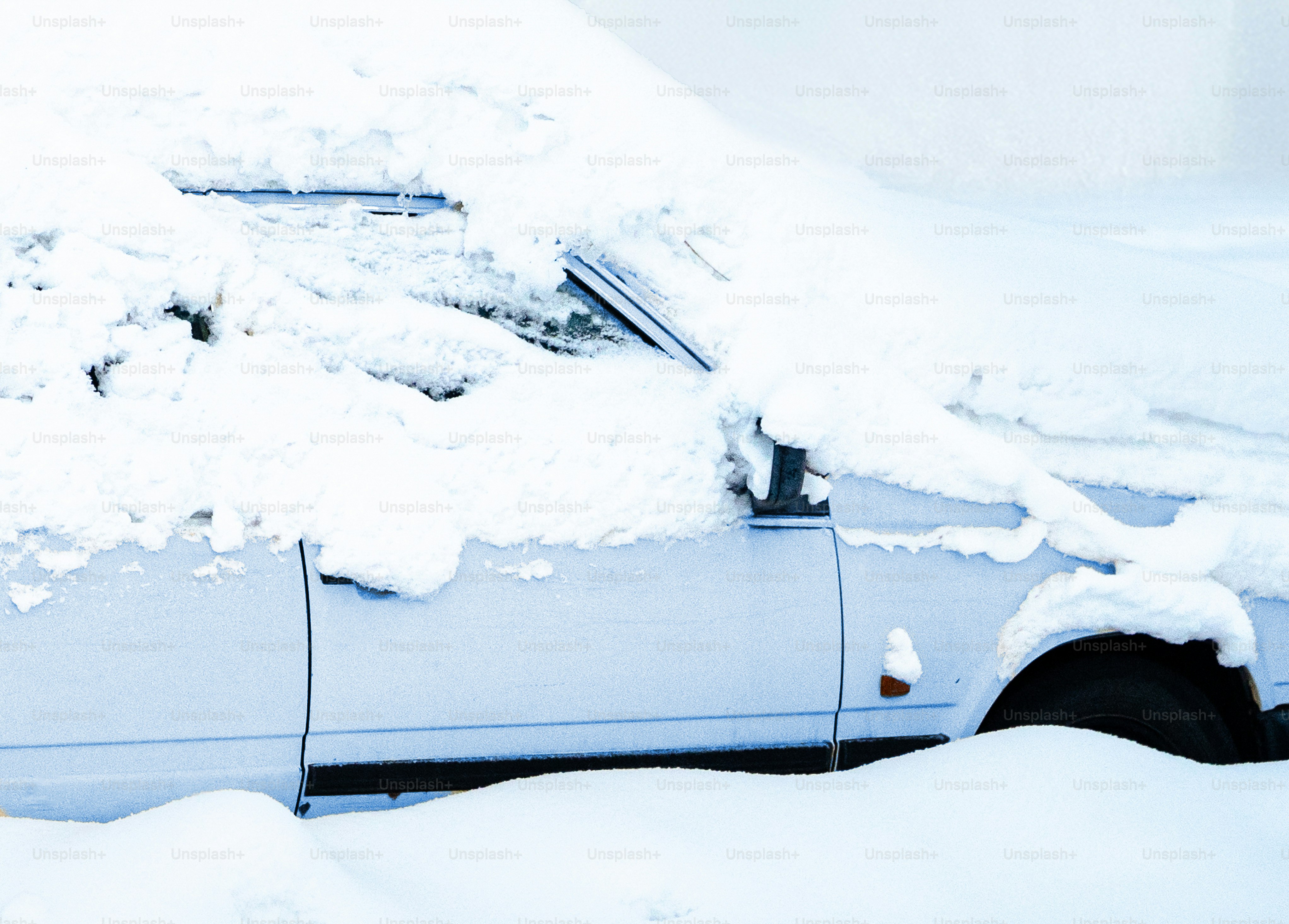 A white car covered in thick snow