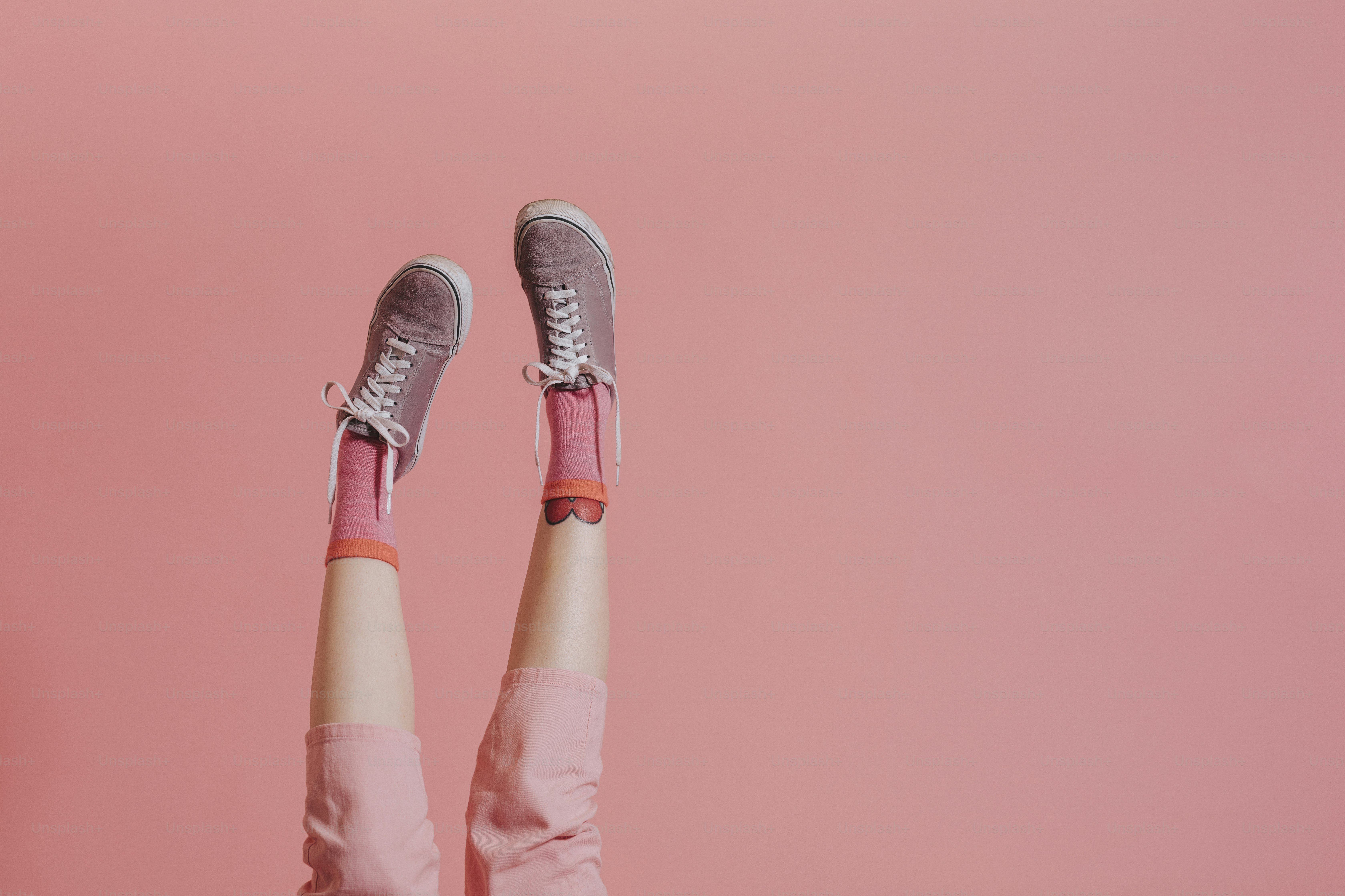 Femme avec les jambes en pantalon rose levées en l’air