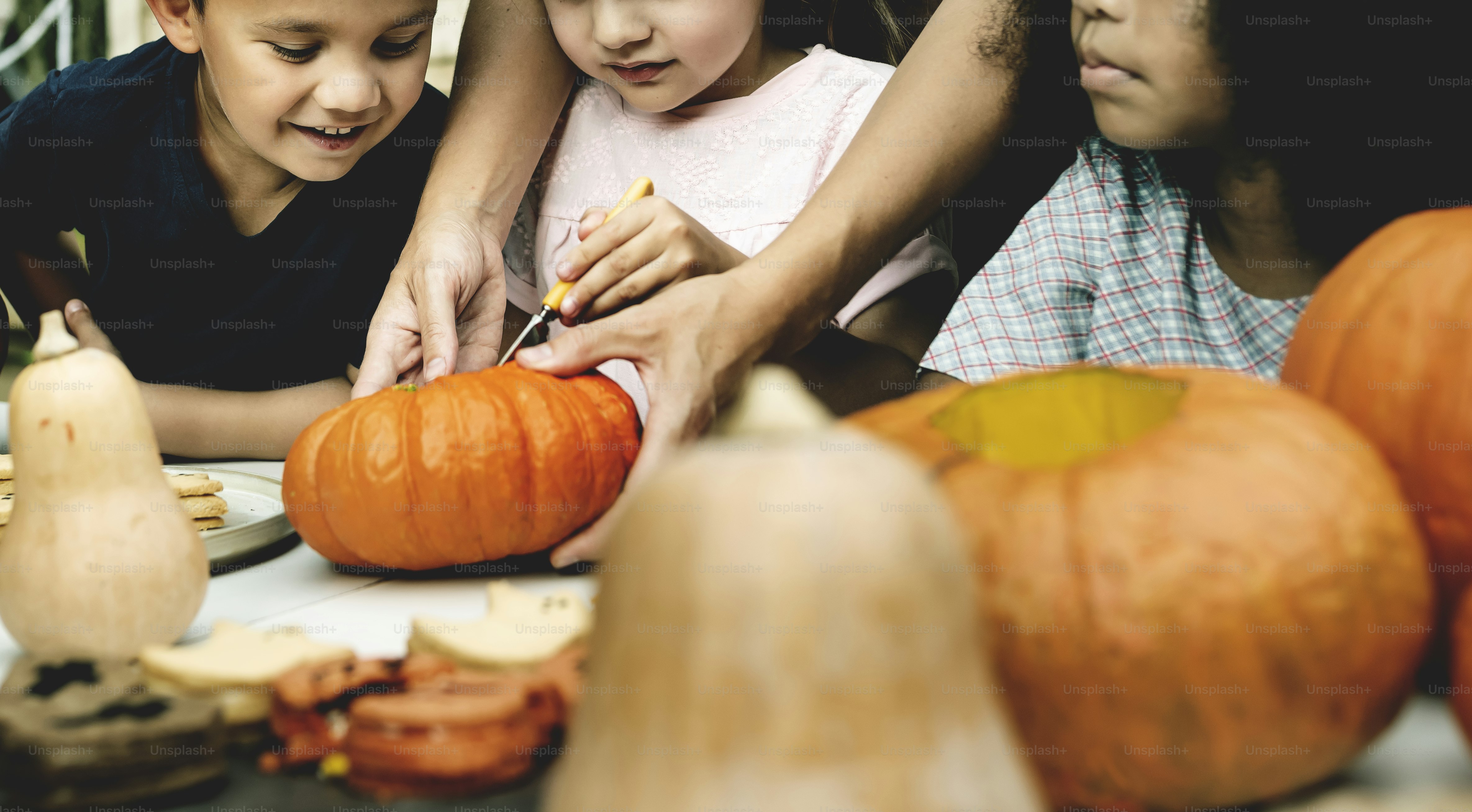 De jeunes enfants sculptant des citrouilles-lanternes d'Halloween