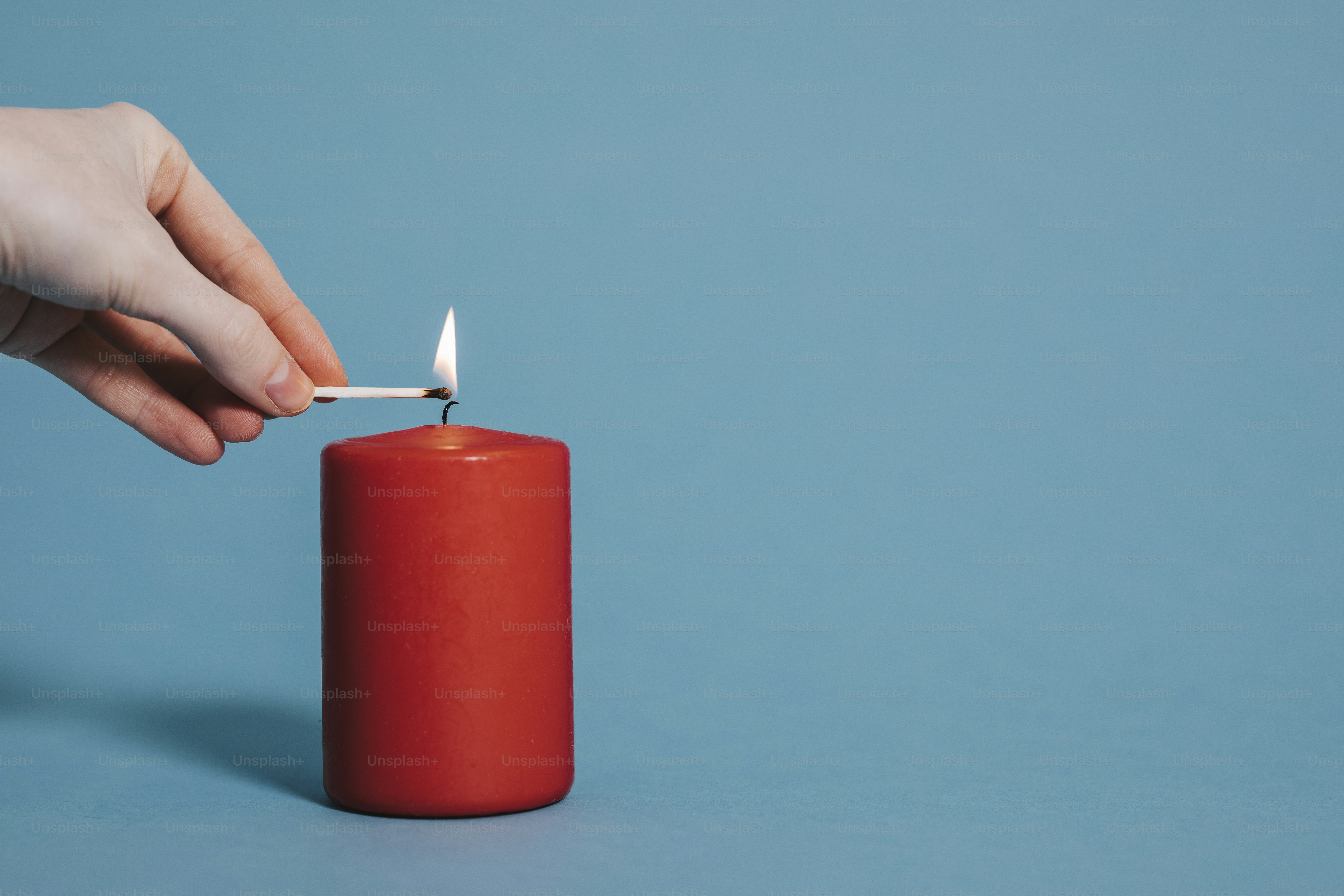 Frau, die eine rote Kerze anzündet