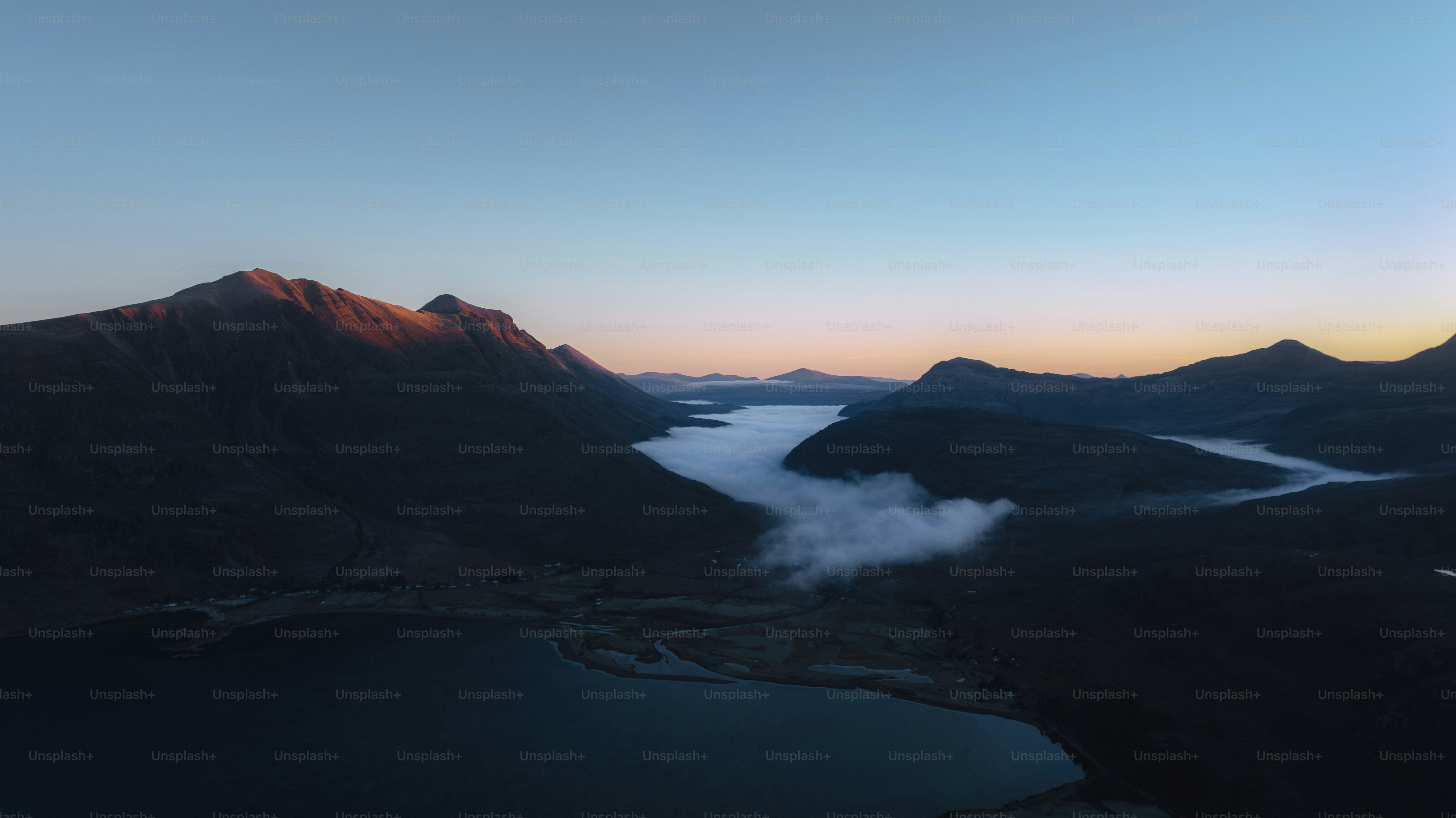 山々と霧に包まれた日の出の川