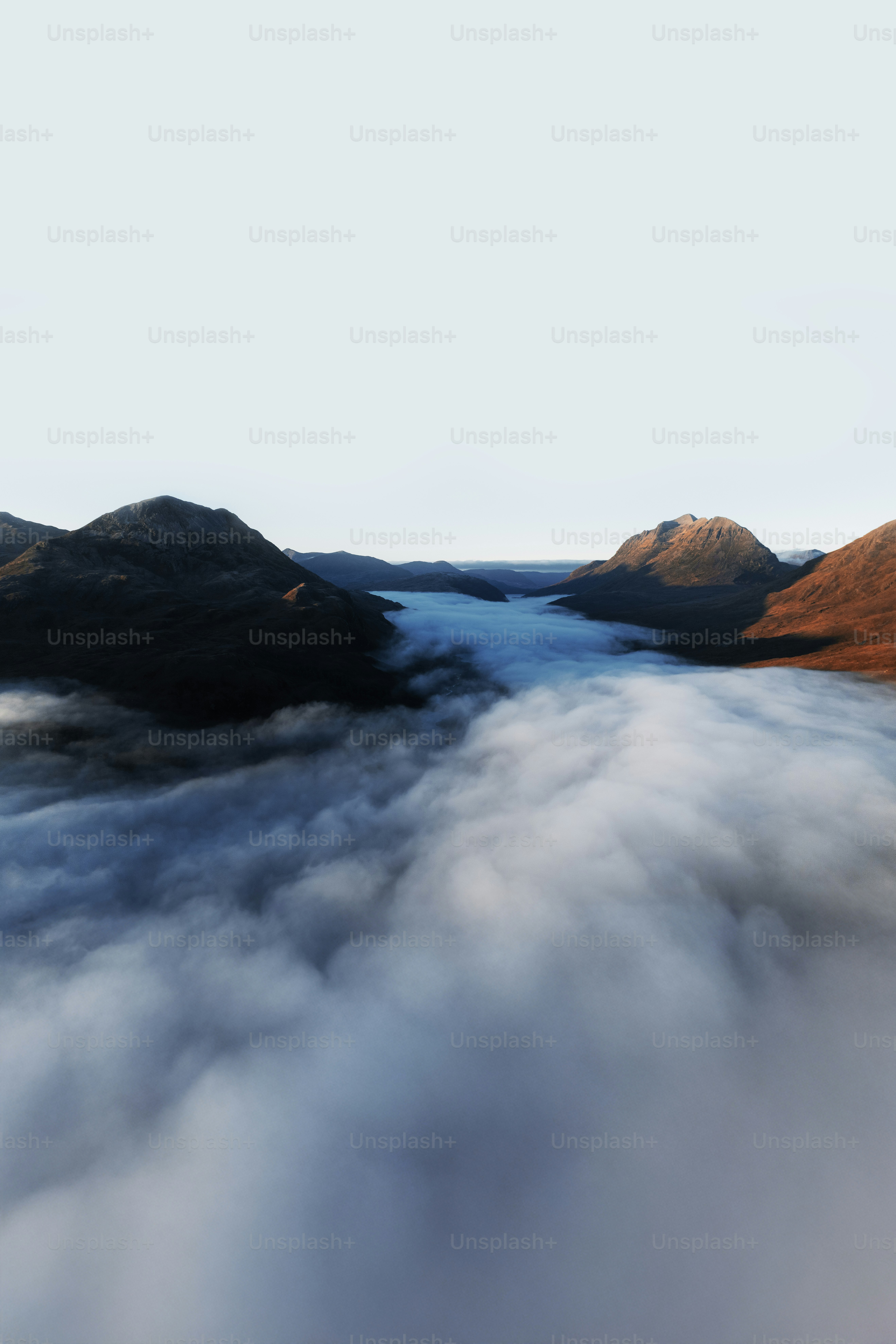 Nebeliges Tal zwischen Bergen bei Sonnenaufgang