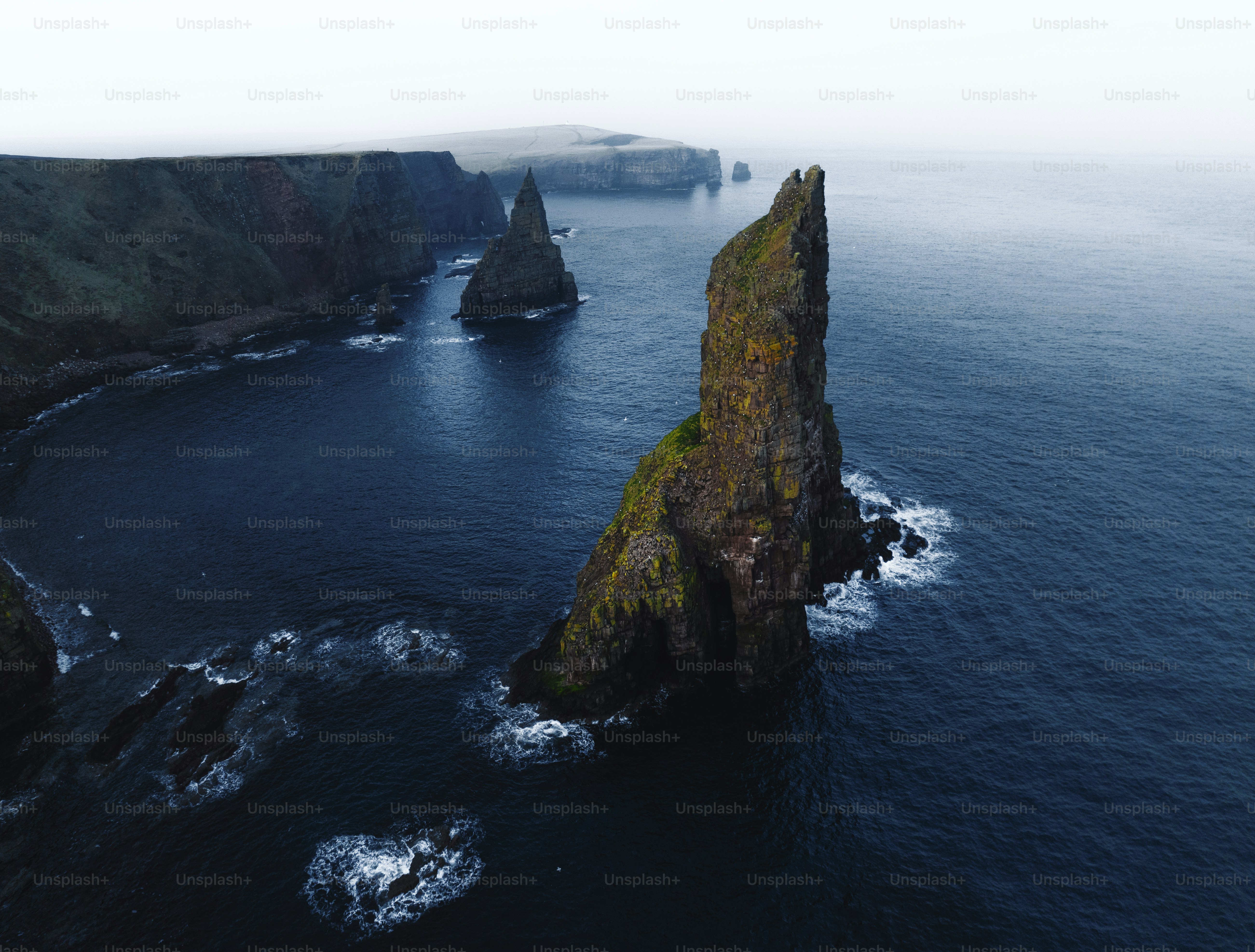 Gezackte Meeresstapel ragen aus dem dunklen Ozean nahe den Klippen empor.