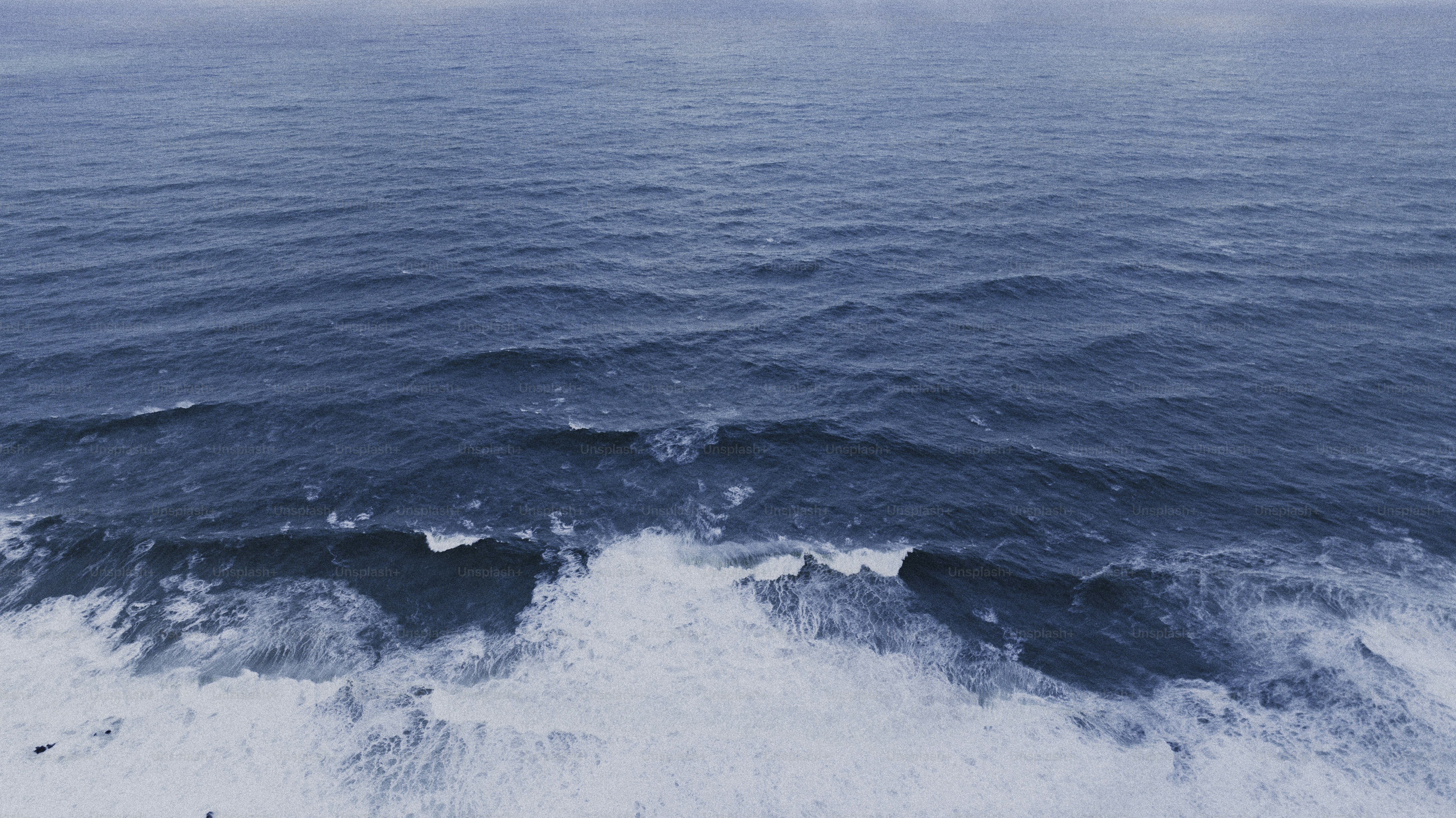 曇り空の下、砂浜に打ち寄せる波