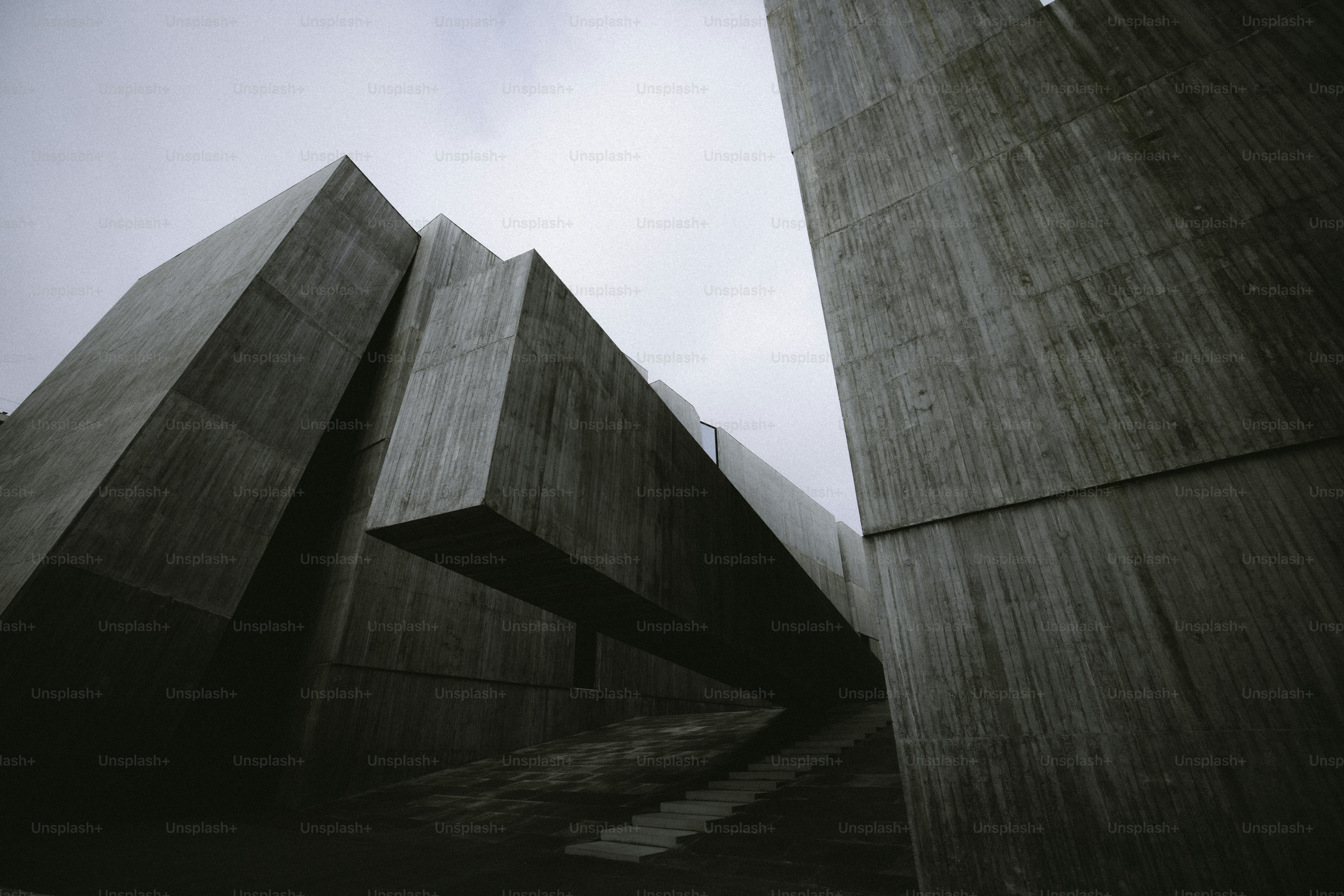 Geometric concrete structures against a cloudy sky.