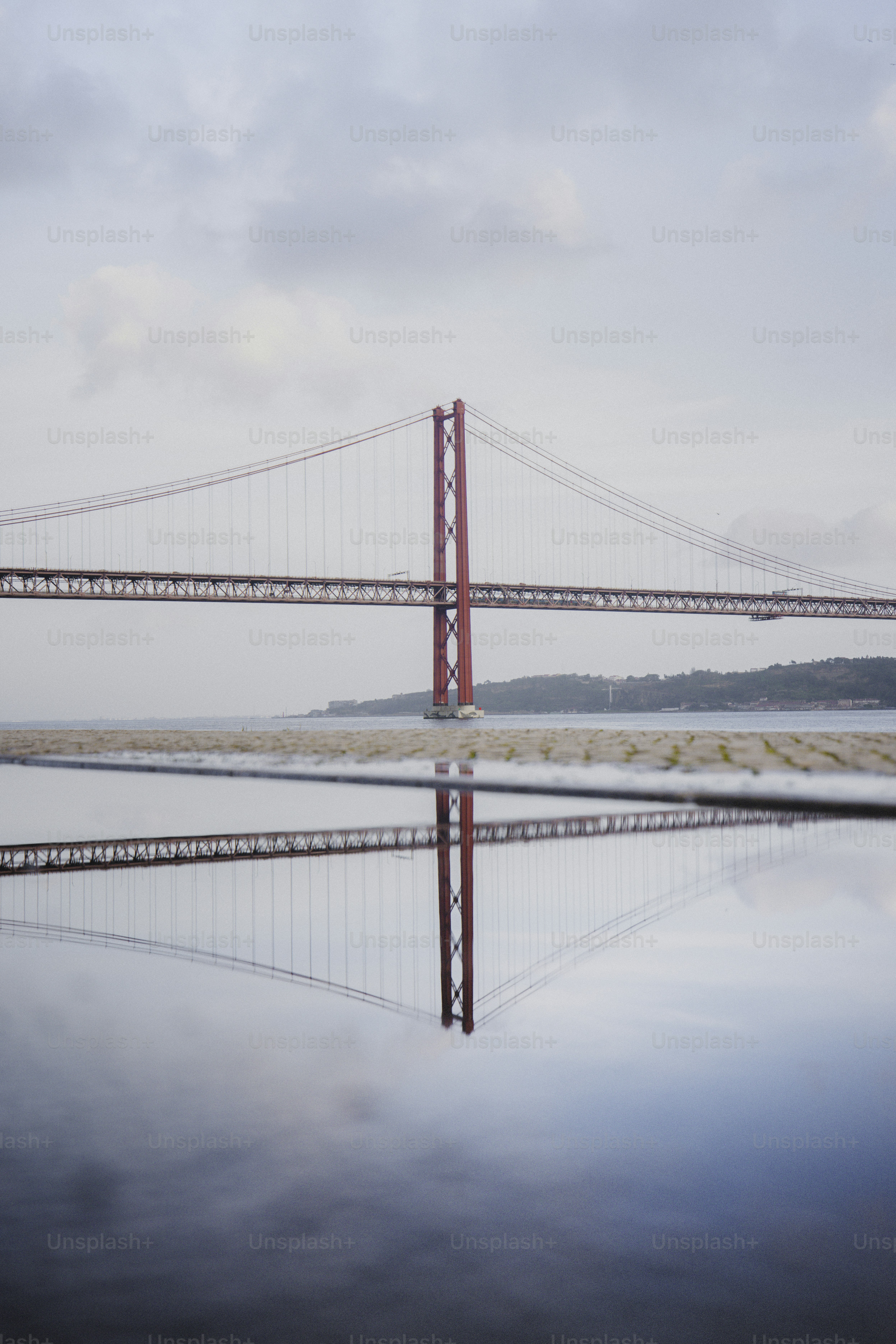 Red suspension bridge reflected in water
