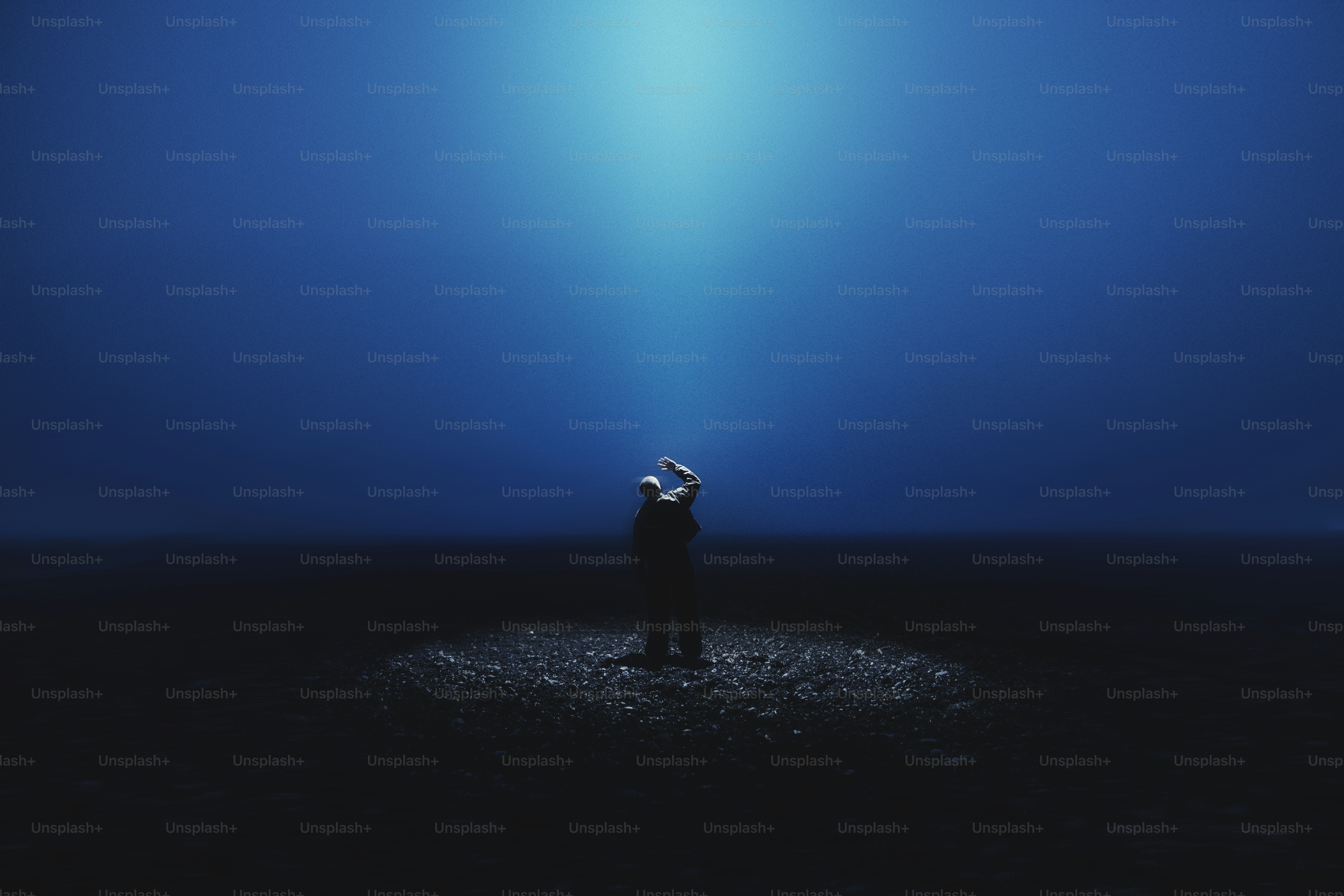 Eine einzelne Gestalt steht von einem Scheinwerfer beleuchtet.