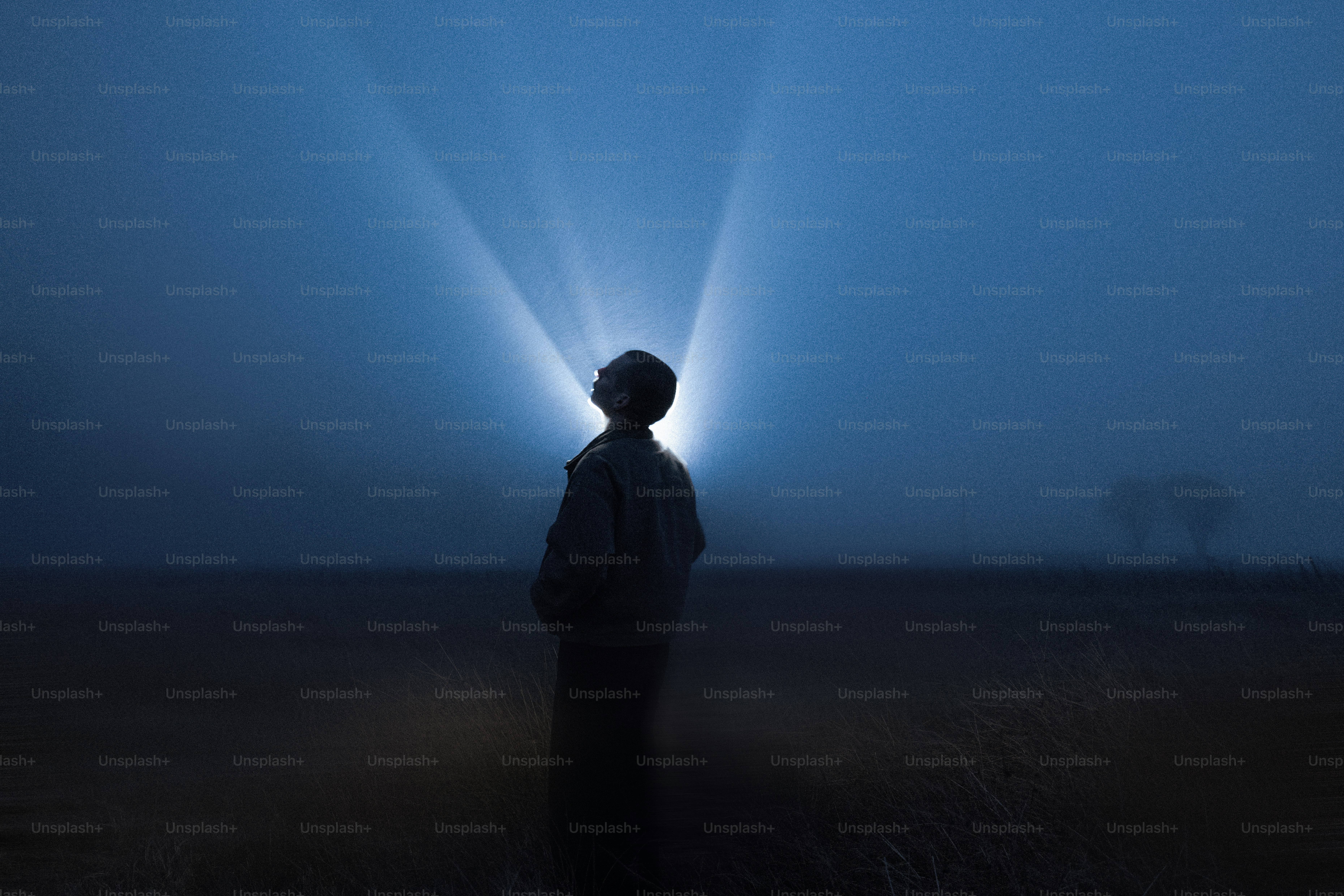 光の光を見上げる人のシルエット