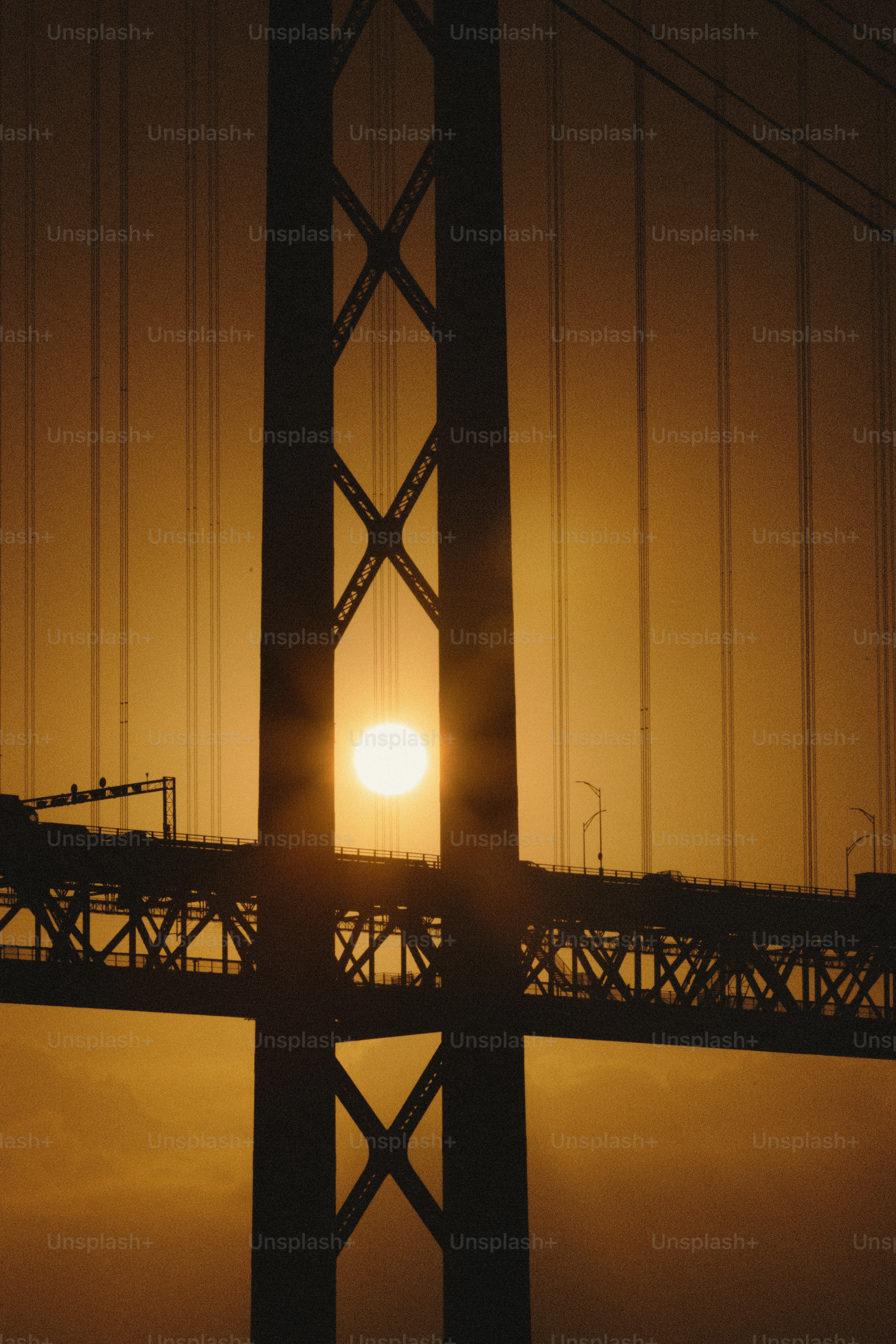 El sol poniéndose detrás de un gran puente colgante.