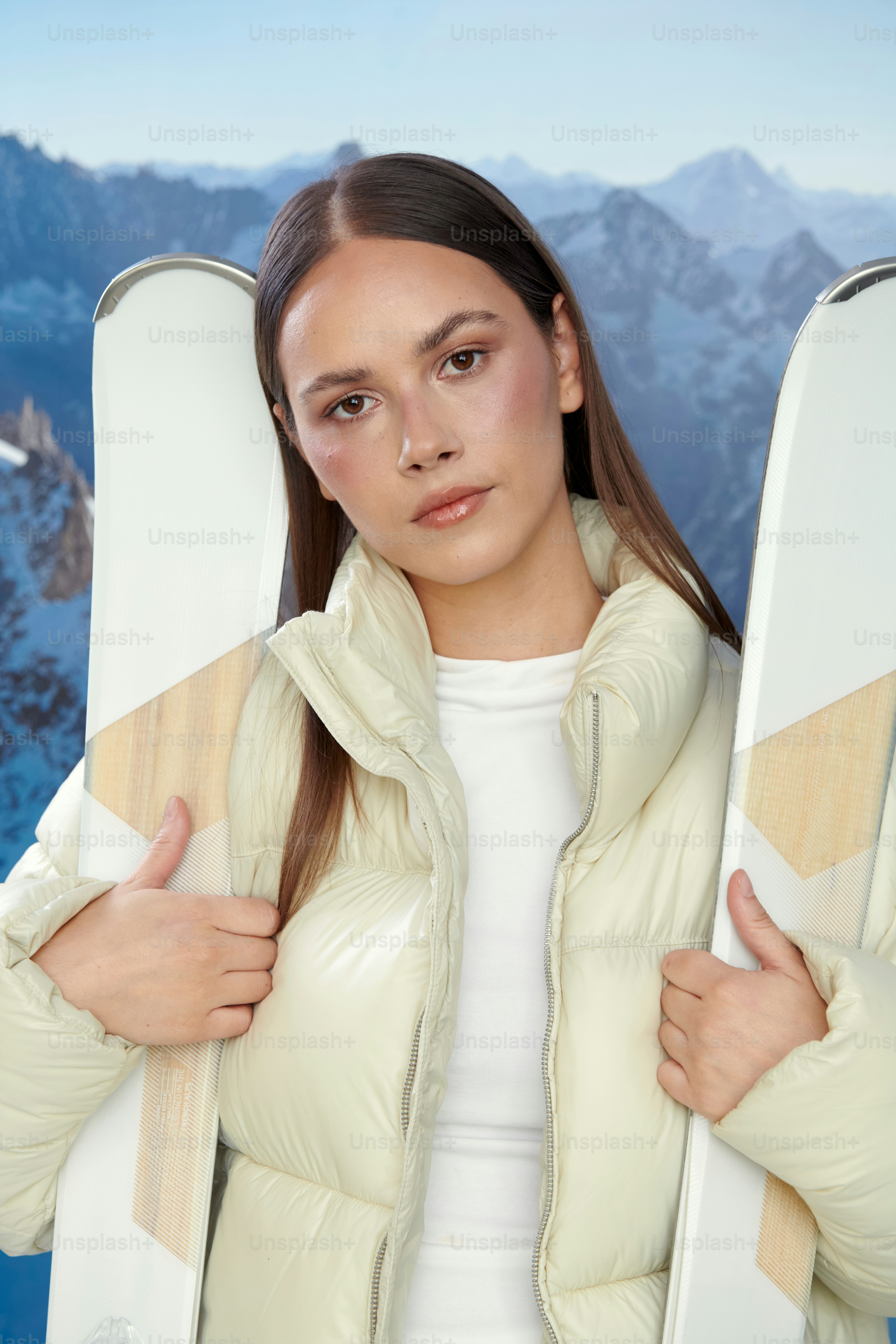 スキージャケットを着た若い女性がスキーを持った