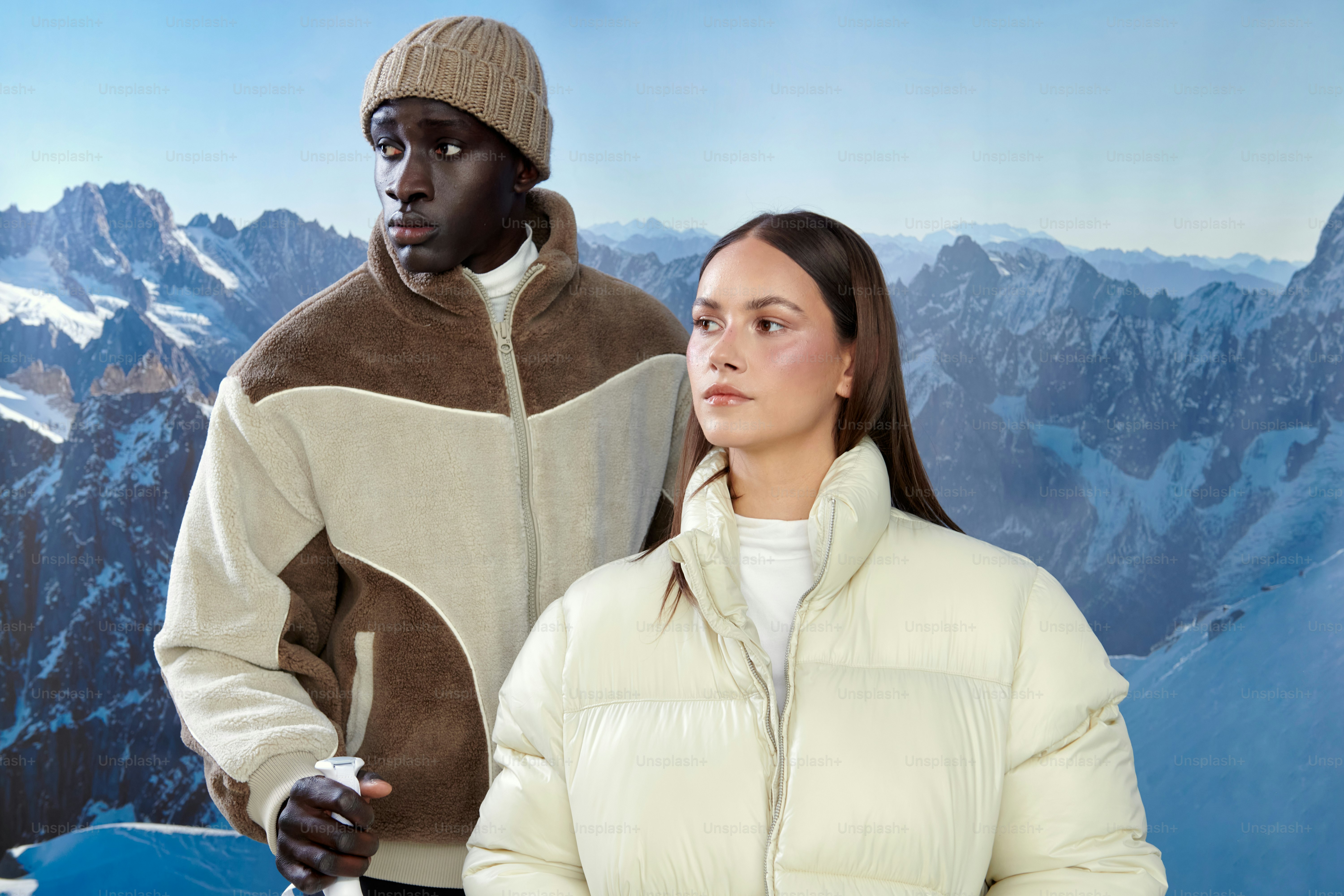 Two people in winter jackets with snowy mountains behind them photo ...