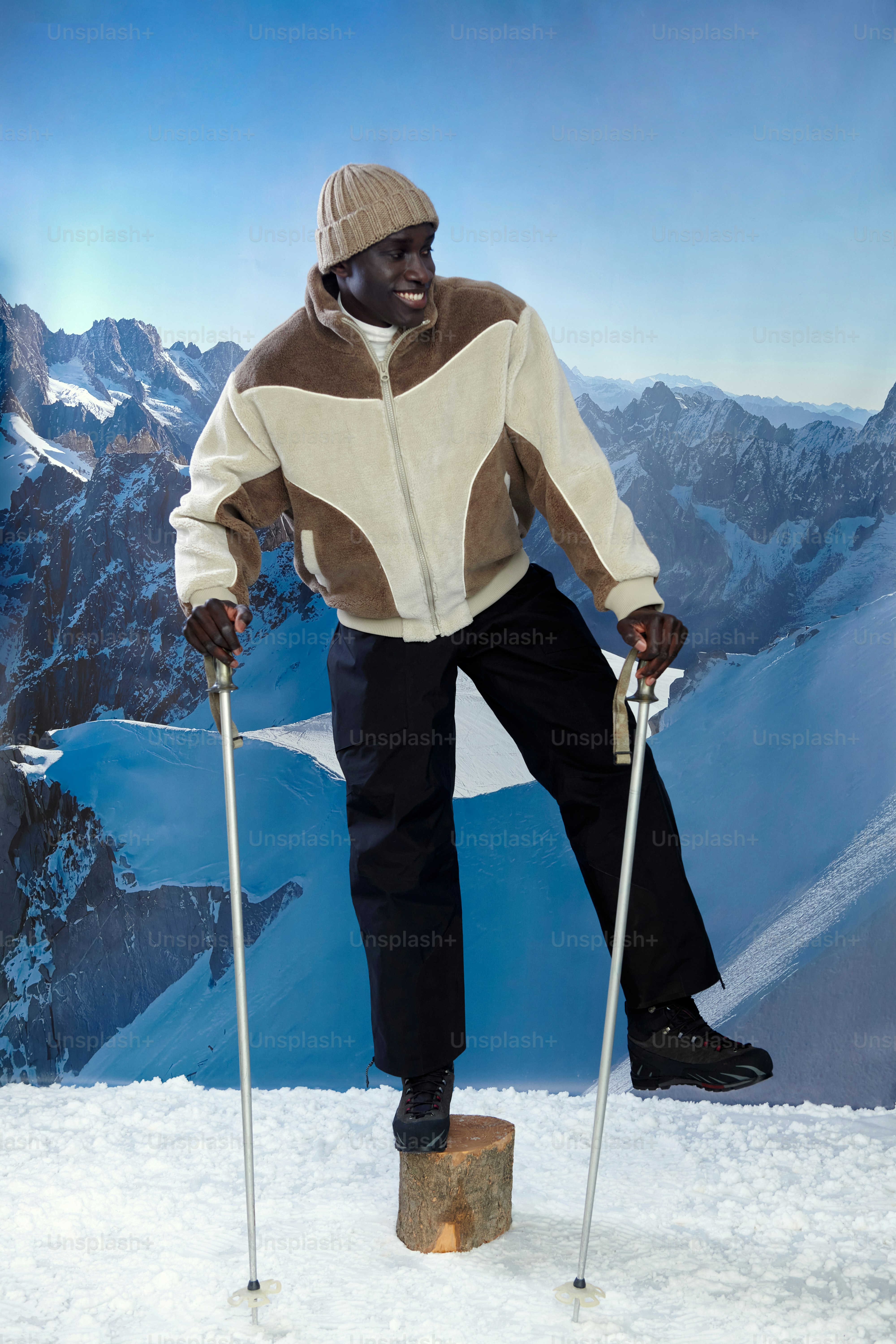 Man in ski gear stands on log with poles
