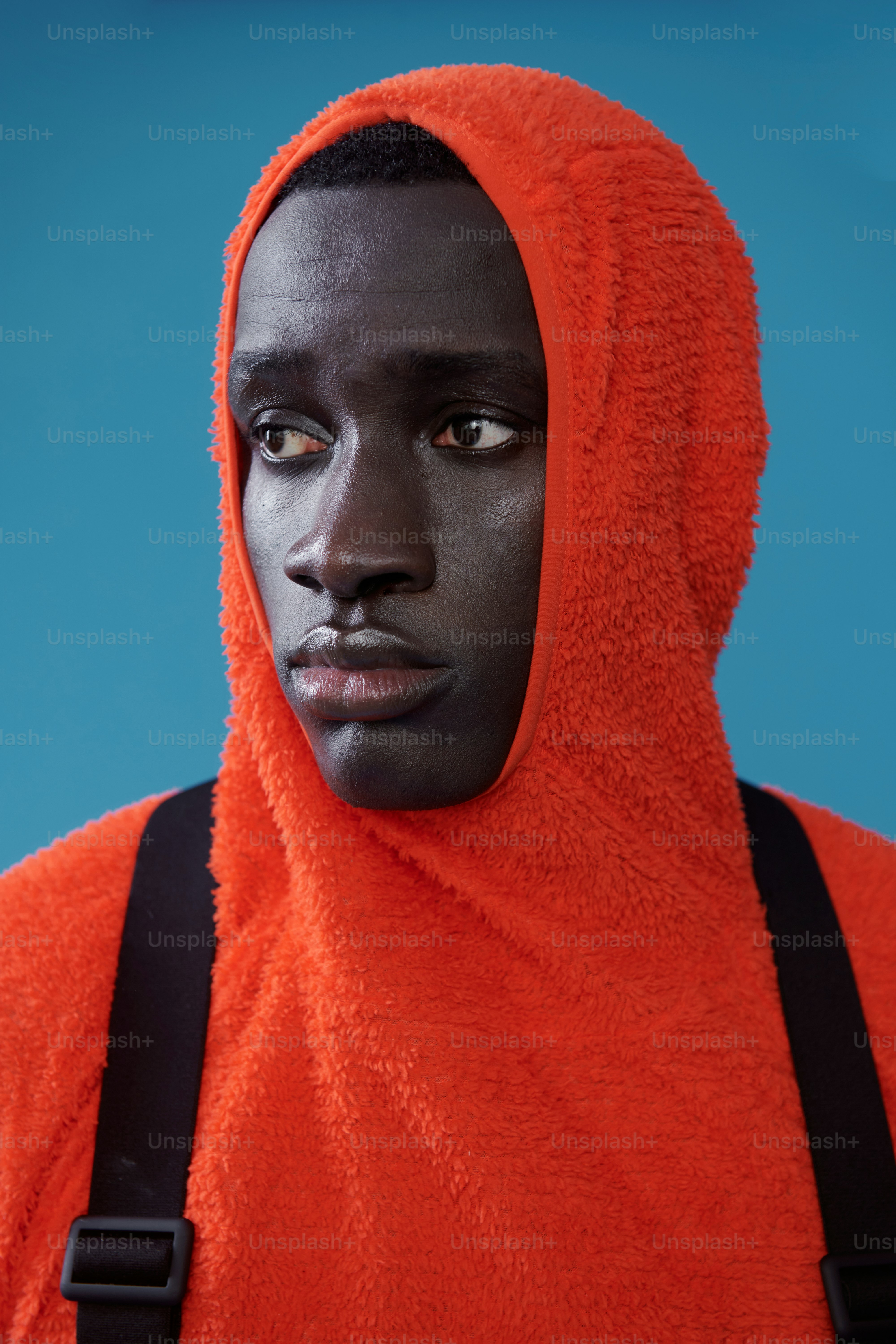 オレンジのパーカーを着た男性がカメラから目をそらす。