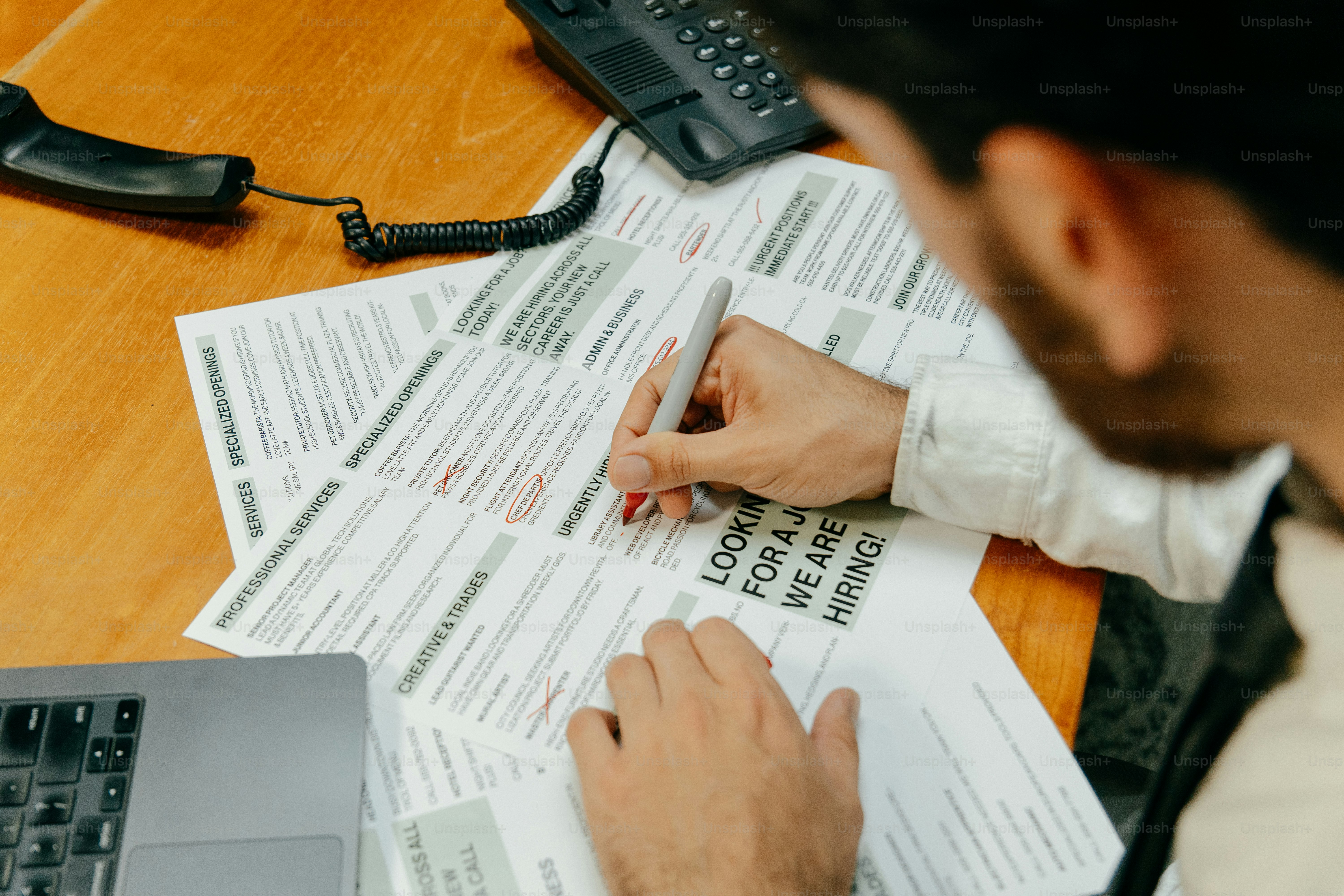 Man filling out job applications at desk.