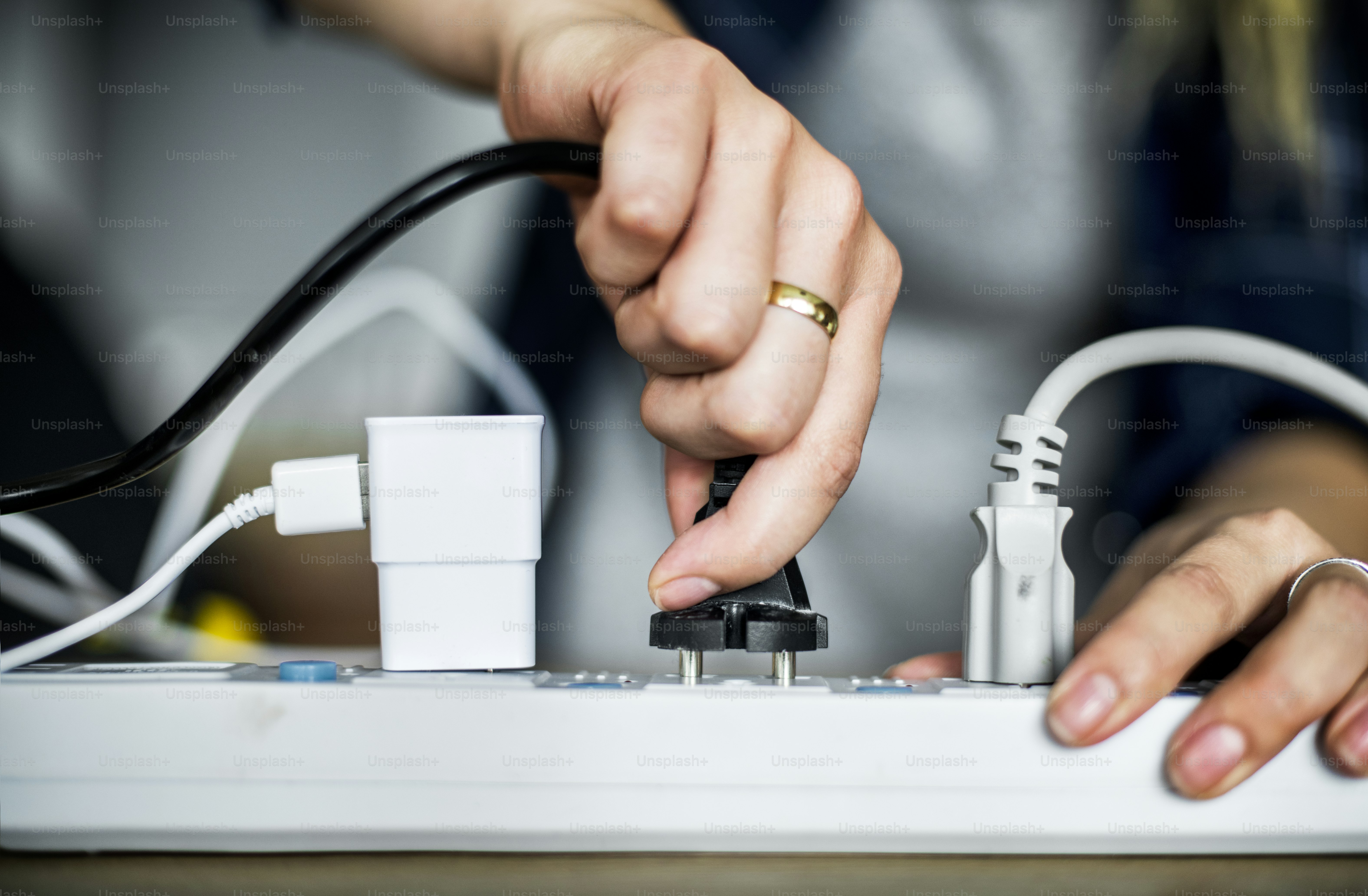 Frau, die das Kabel an die Steckdose steckt