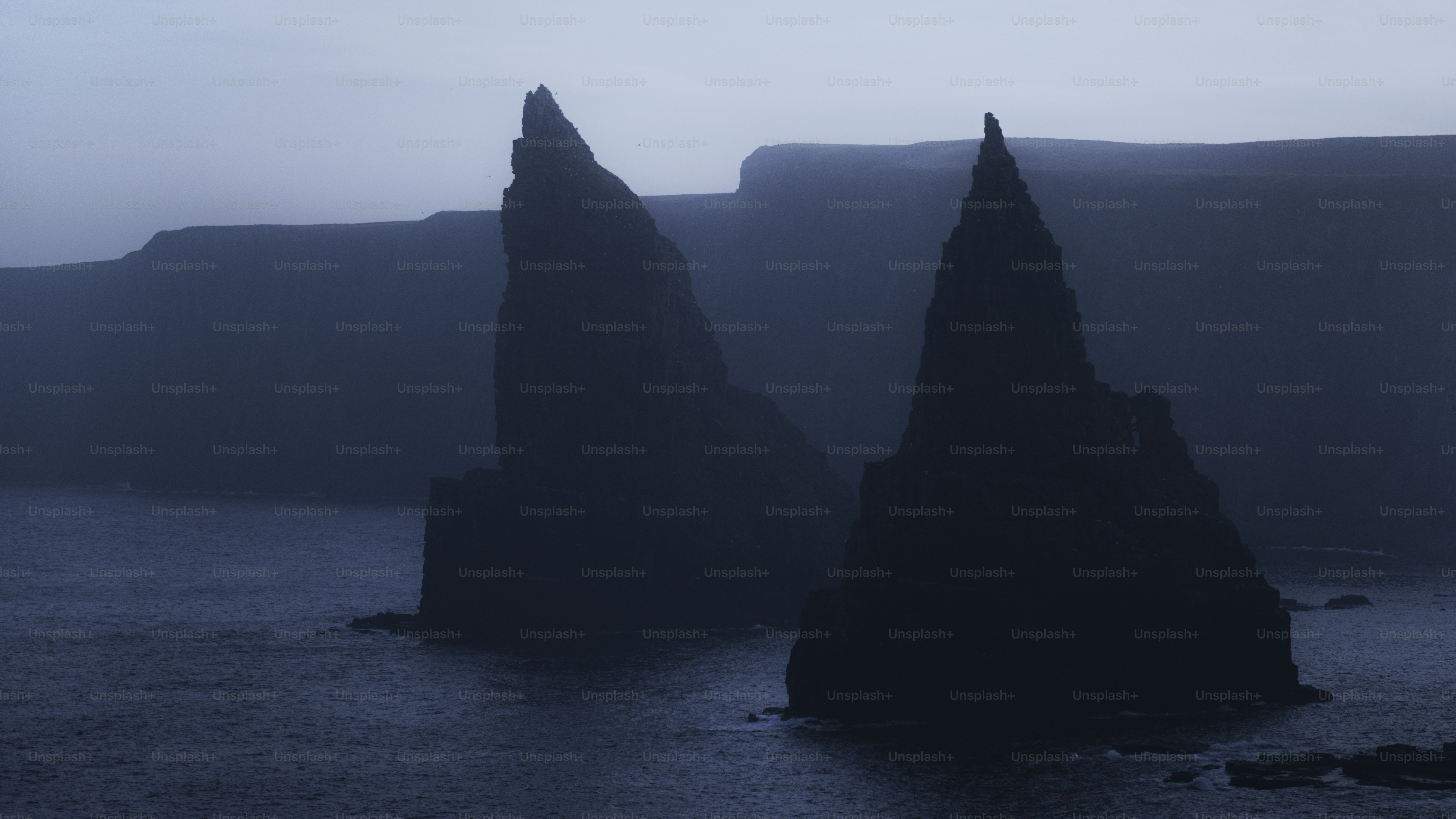 Gezackte Felsformationen erheben sich aus dem dunklen Ozean.