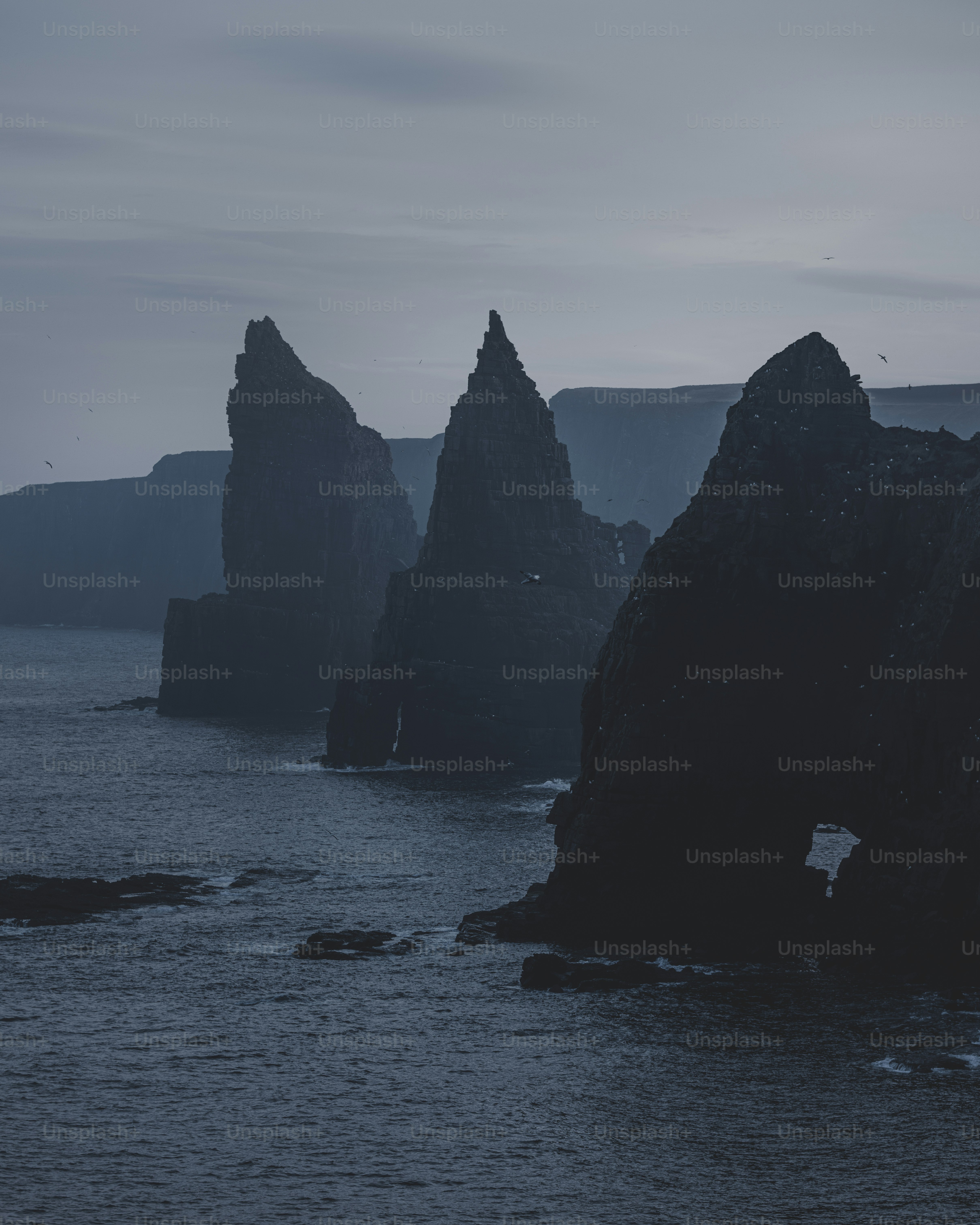 暗い海からギザギザの岩の形成がそびえ立っています。