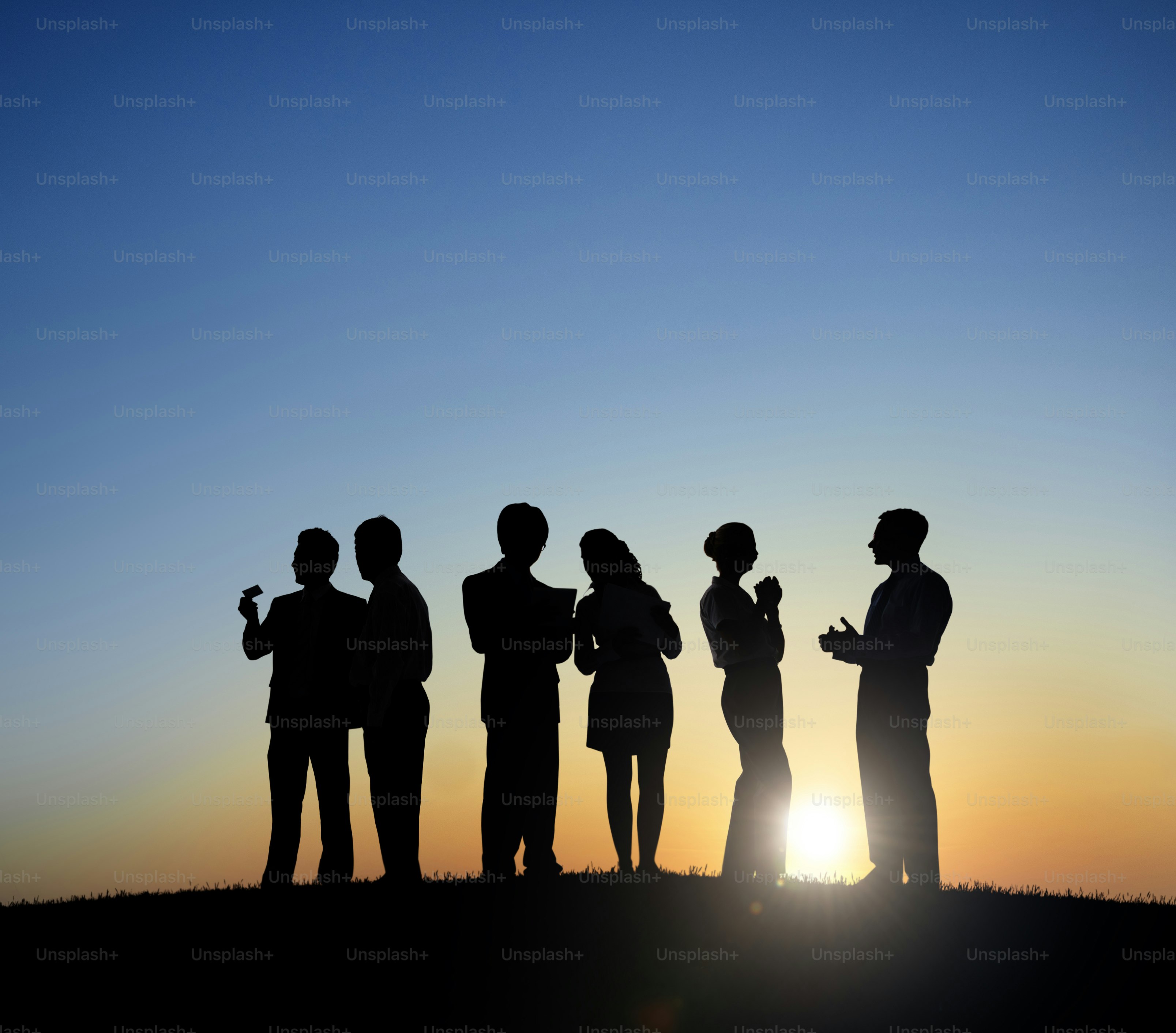 Silhouettes of people standing on a hill at sunset. photo – Business ...