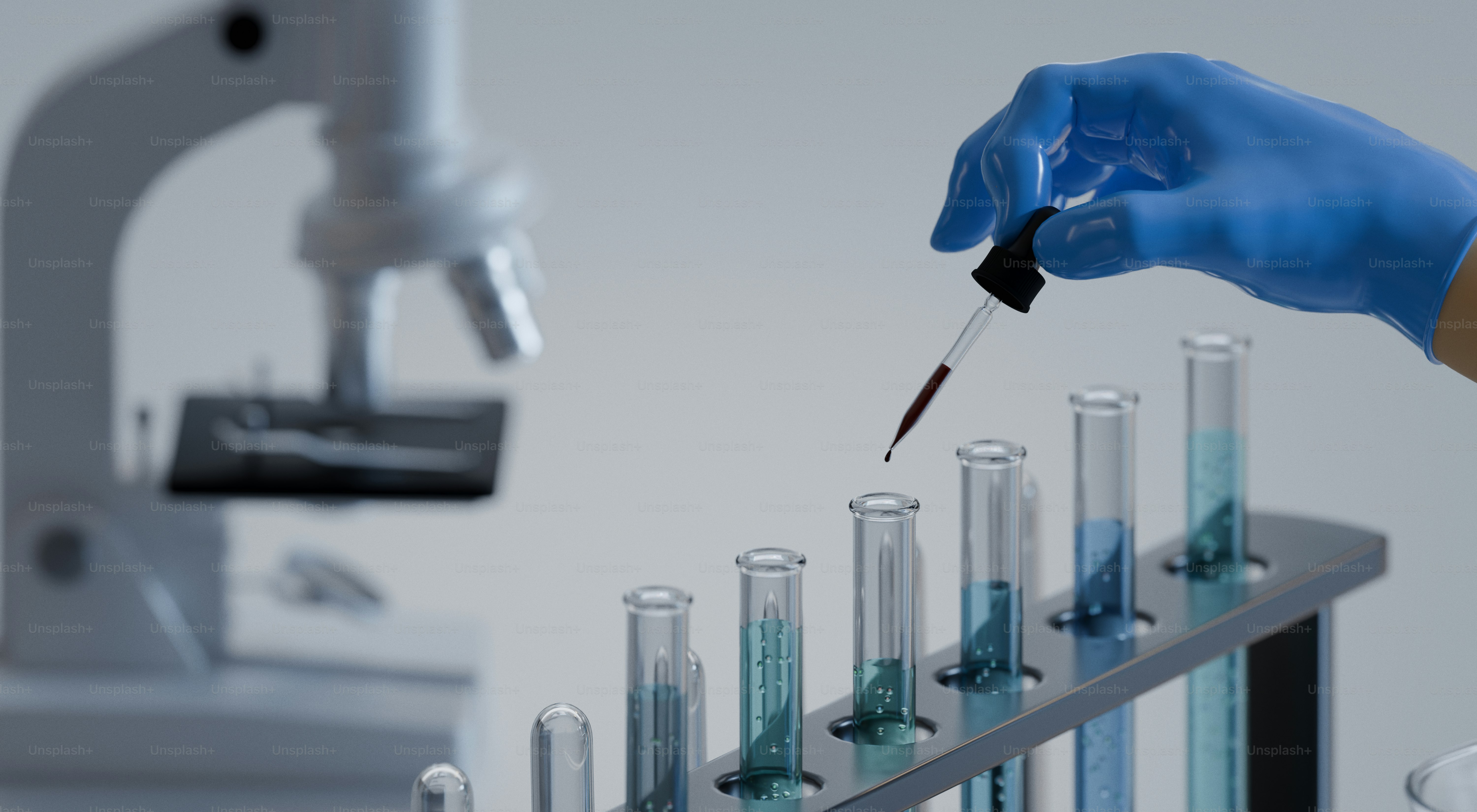 Scientist adds liquid to test tubes in a lab. photo – Medical Image on ...