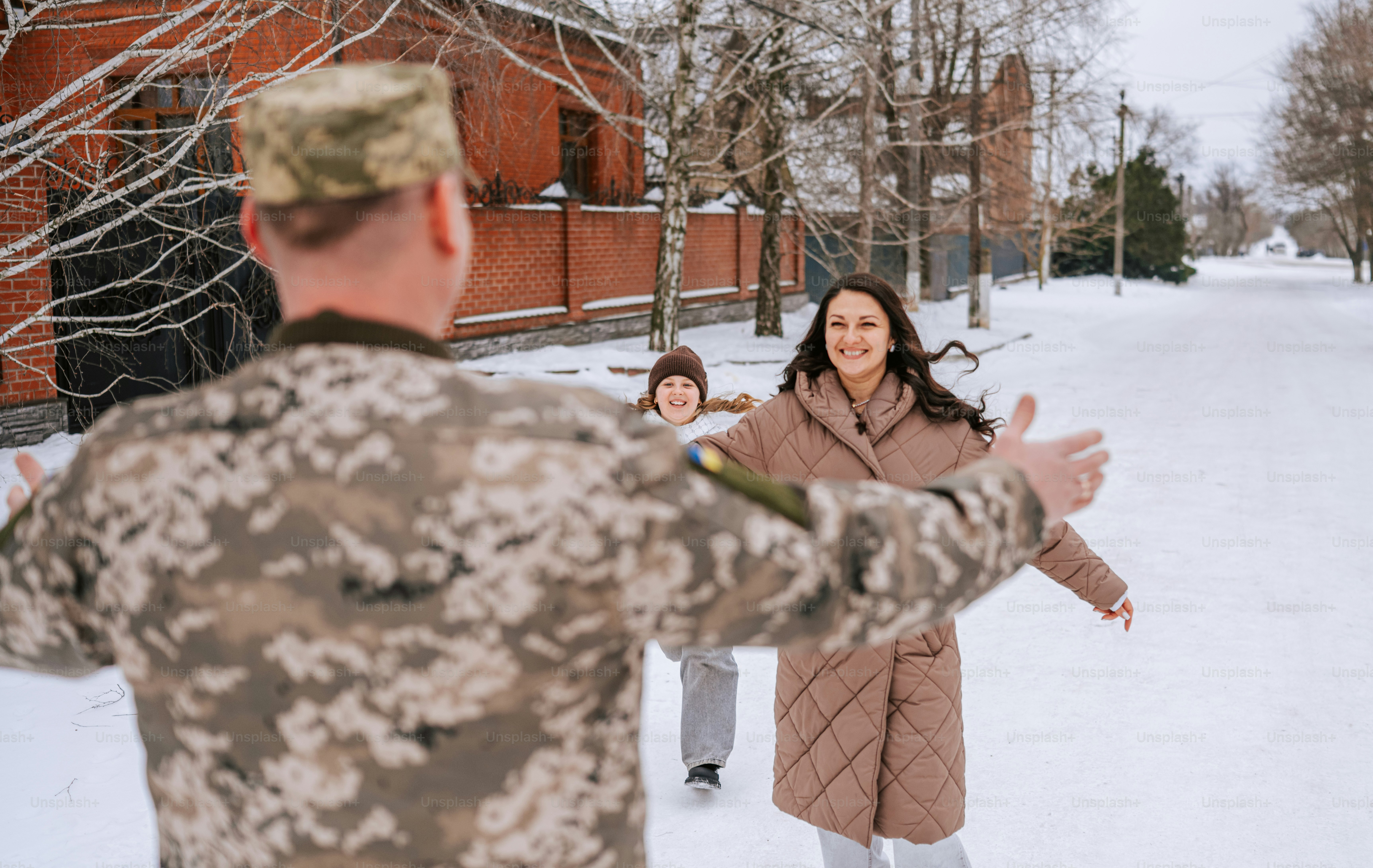 Soldat retrouve sa famille souriante dans un décor enneigé en plein air