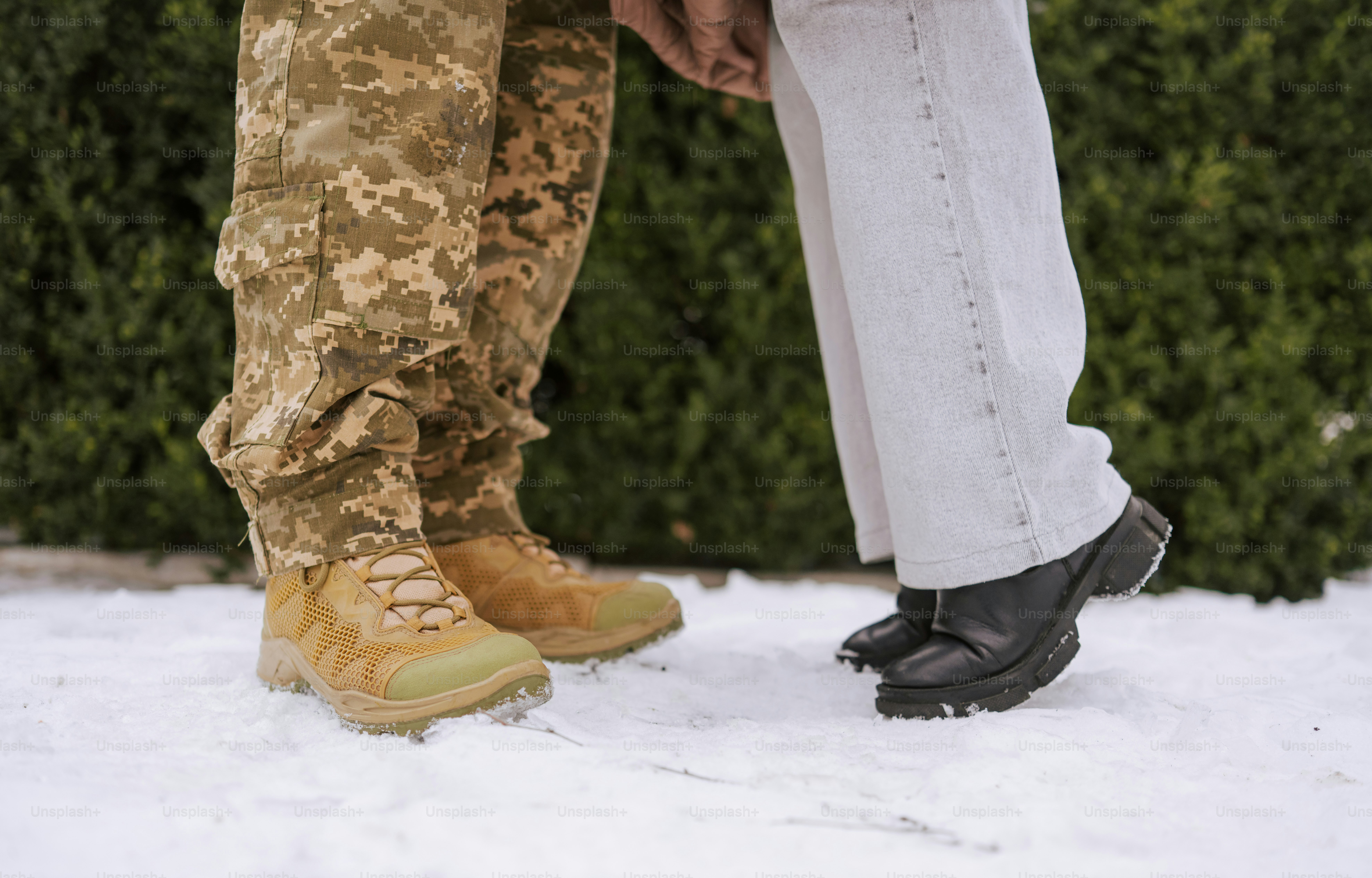 Soldat en camouflage serrant un civil dans la neige