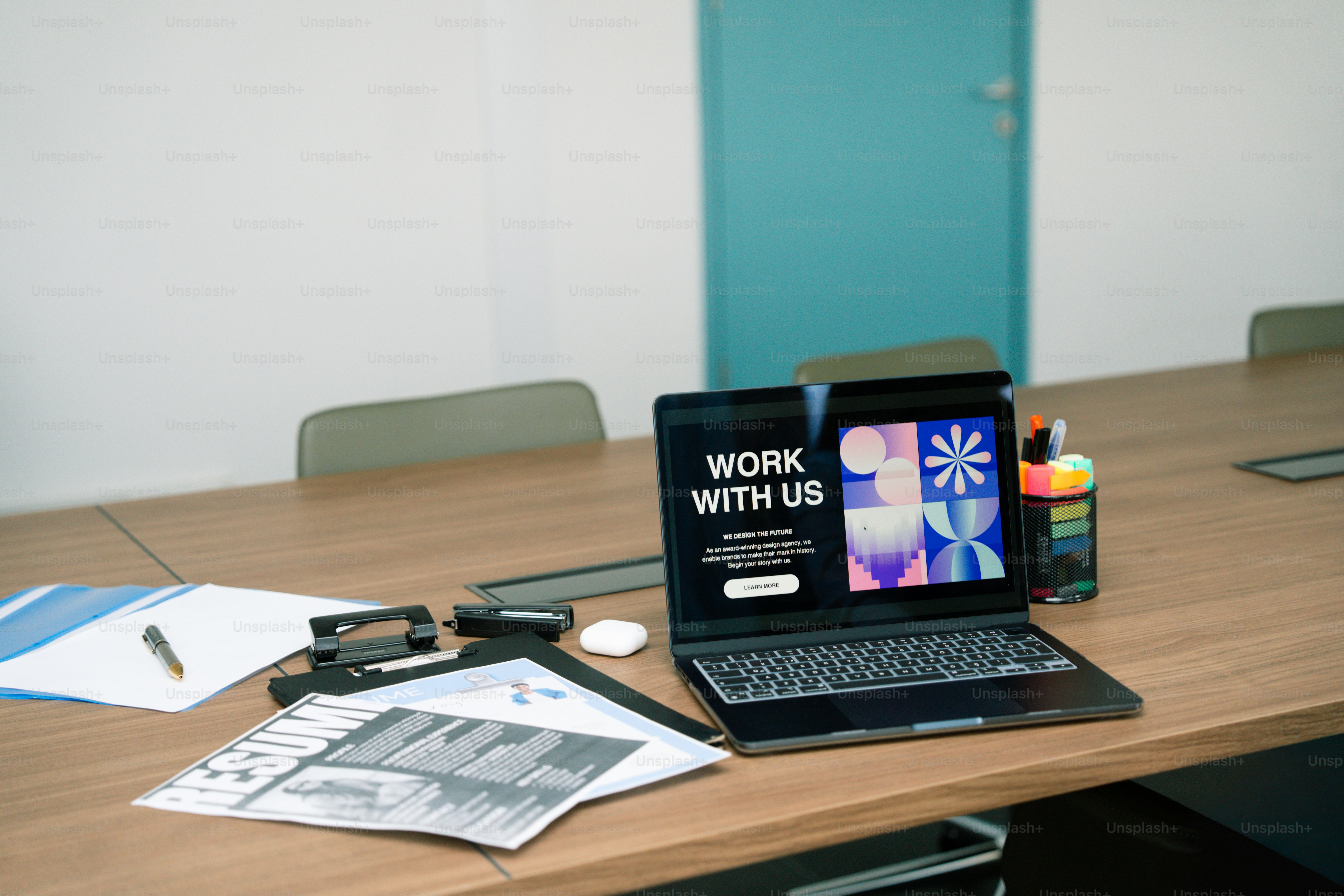 Ordinateur portable affichant « travaille avec nous » sur une table de conférence.