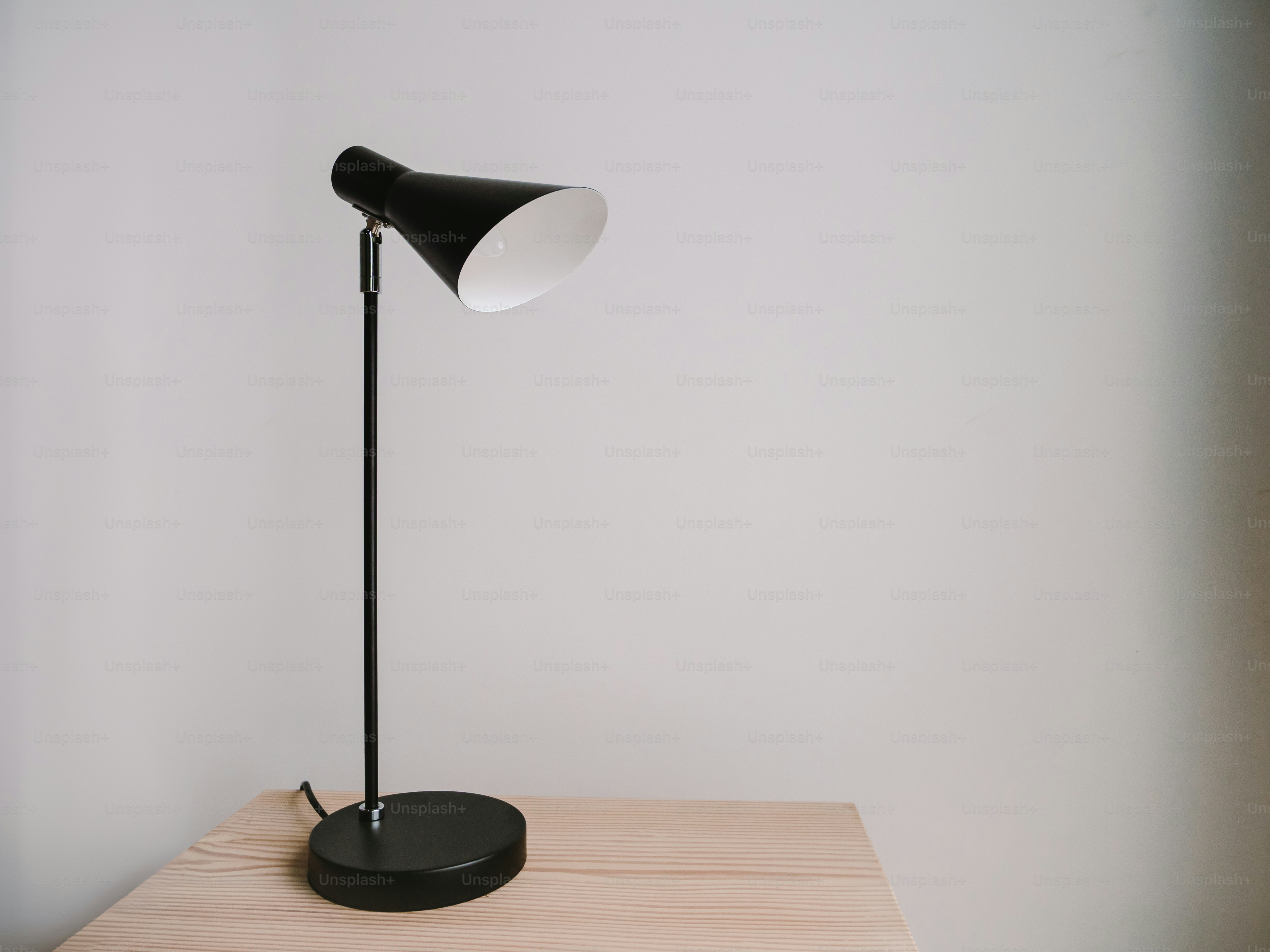 Una lámpara negra sobre una mesa de madera.
