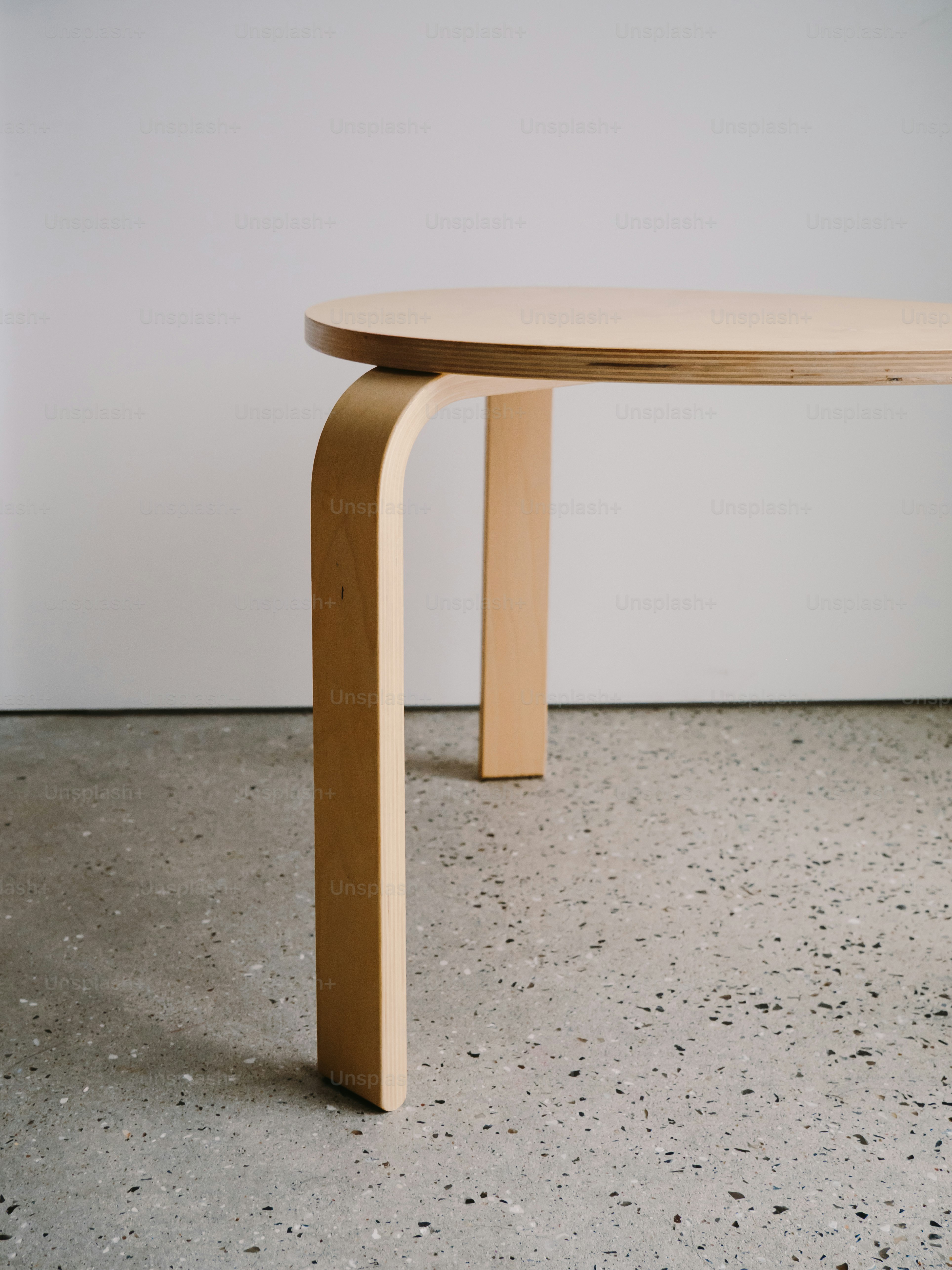 Una mesa minimalista de madera con patas curvas