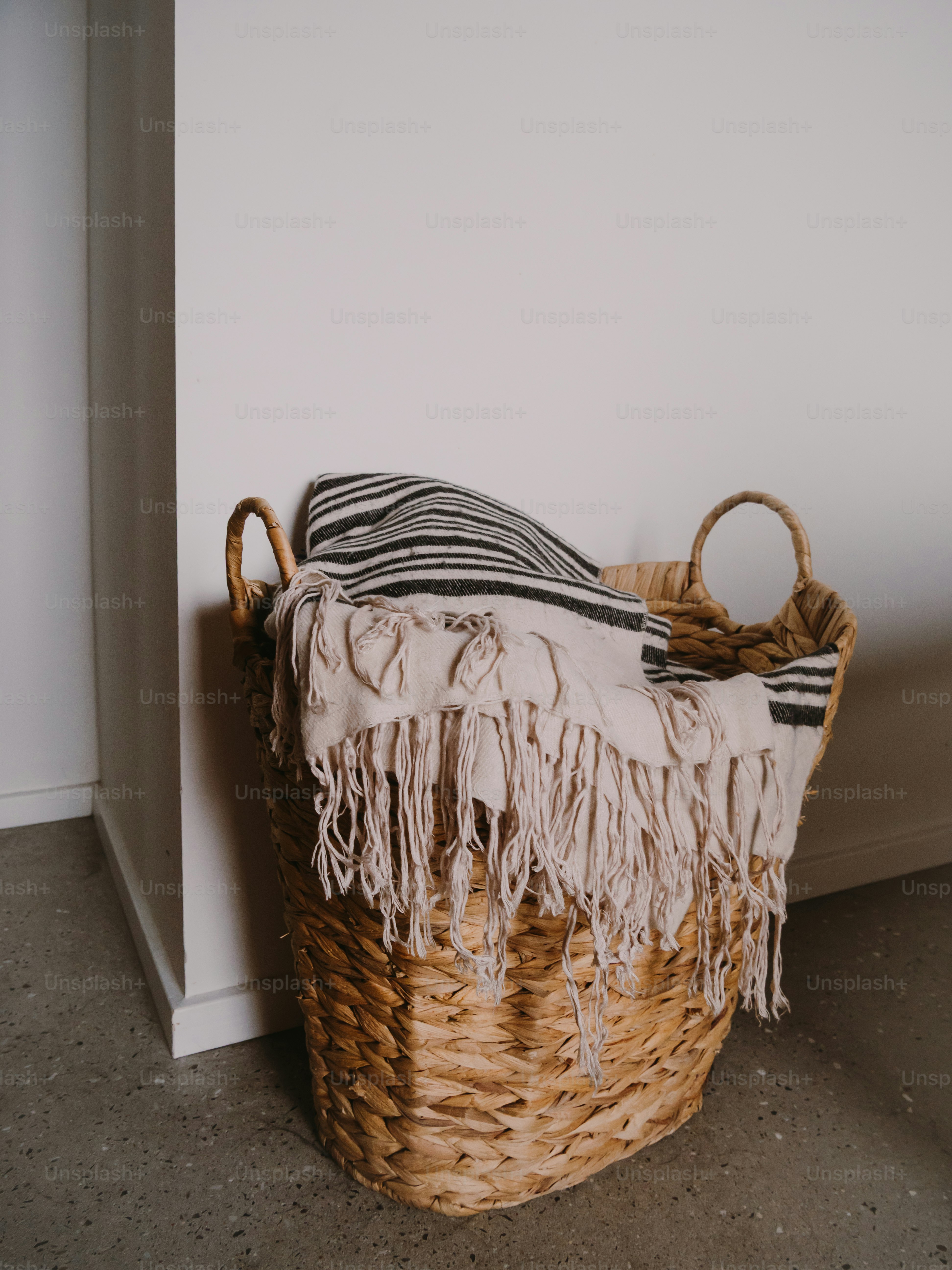 Geflochtener Korb mit gestreifter Decke und Fransen. Foto – Bild zum Thema Textur auf Unsplash