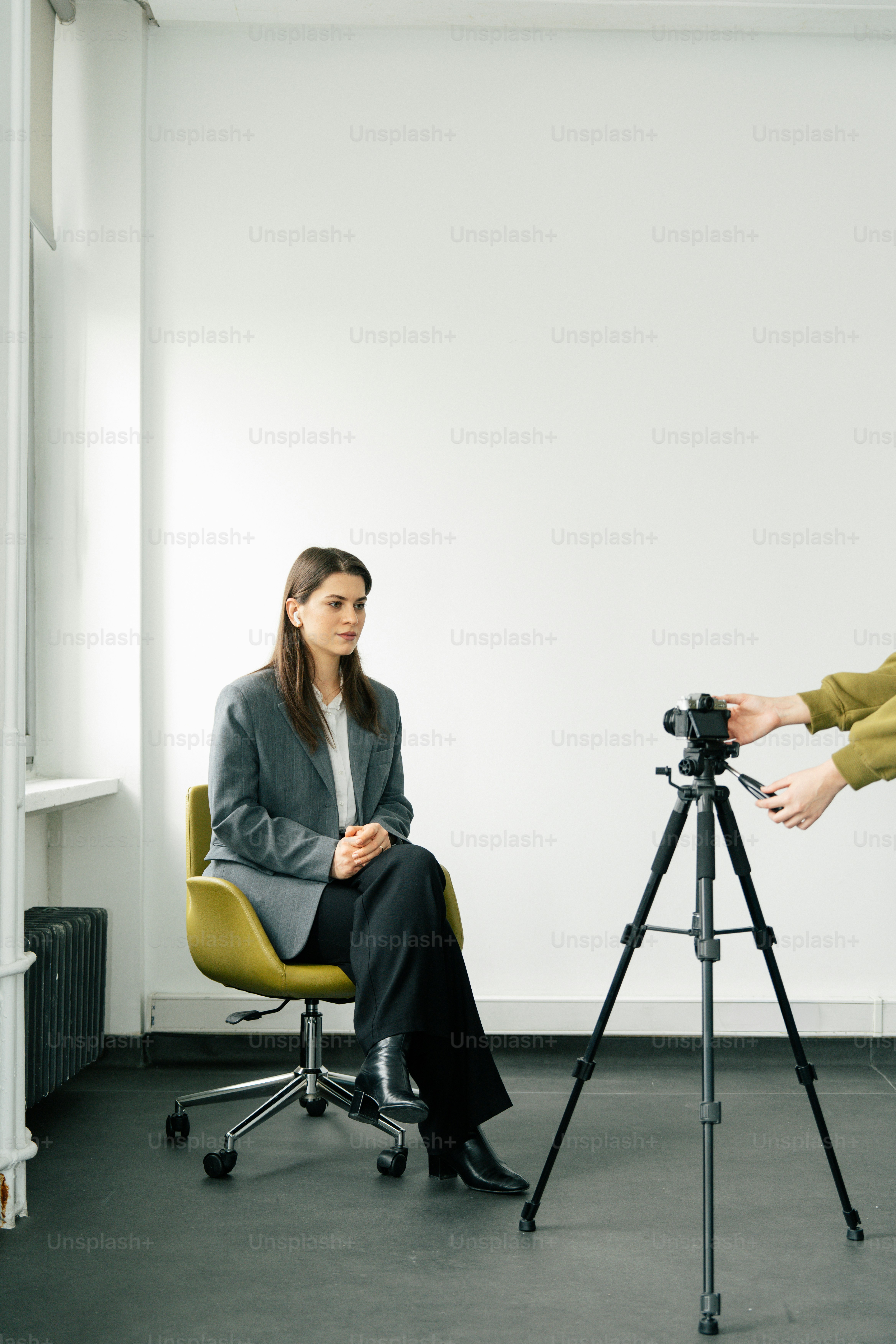 A woman in a suit sits for a video recording.