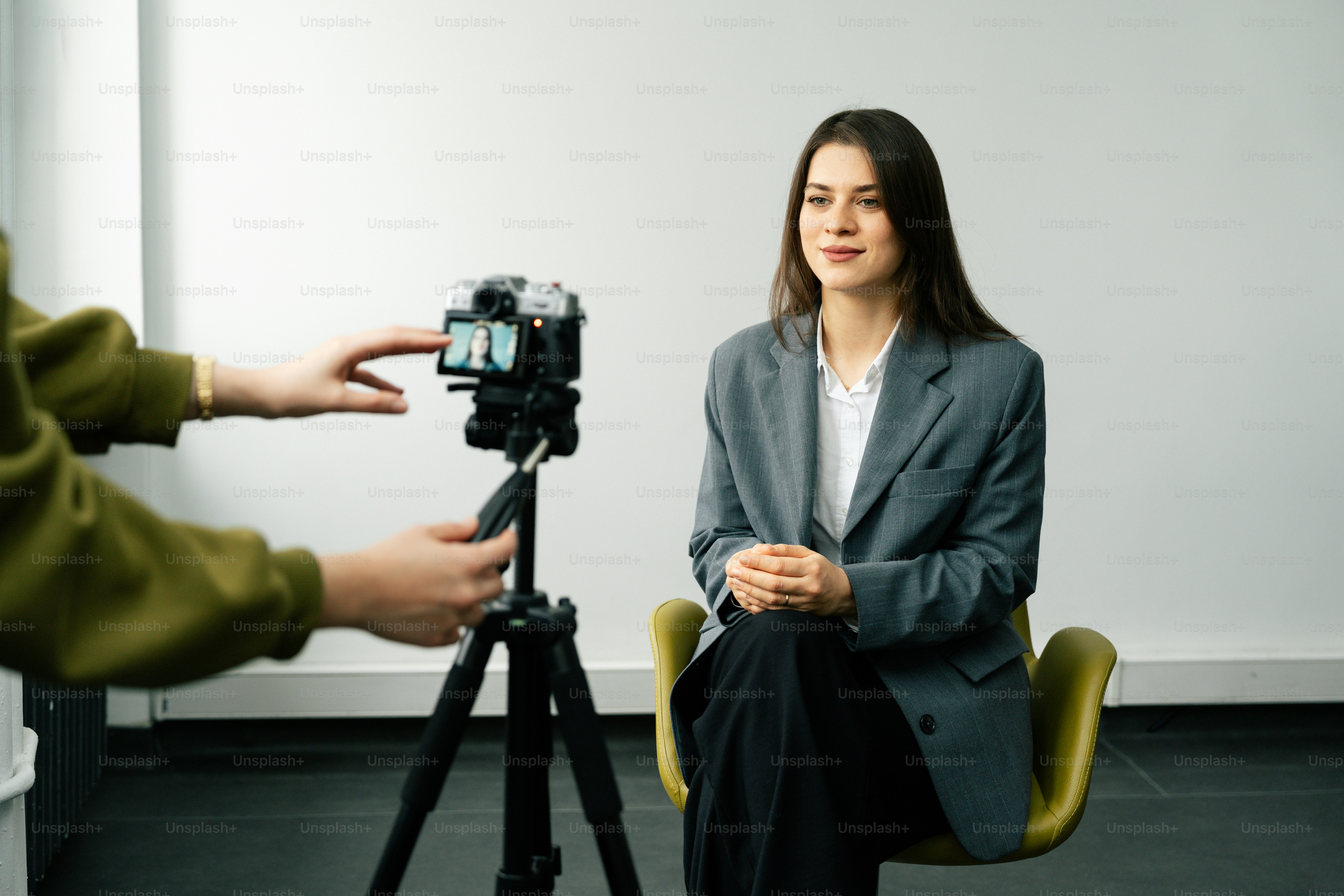 Woman in suit being filmed by a camera on tripod