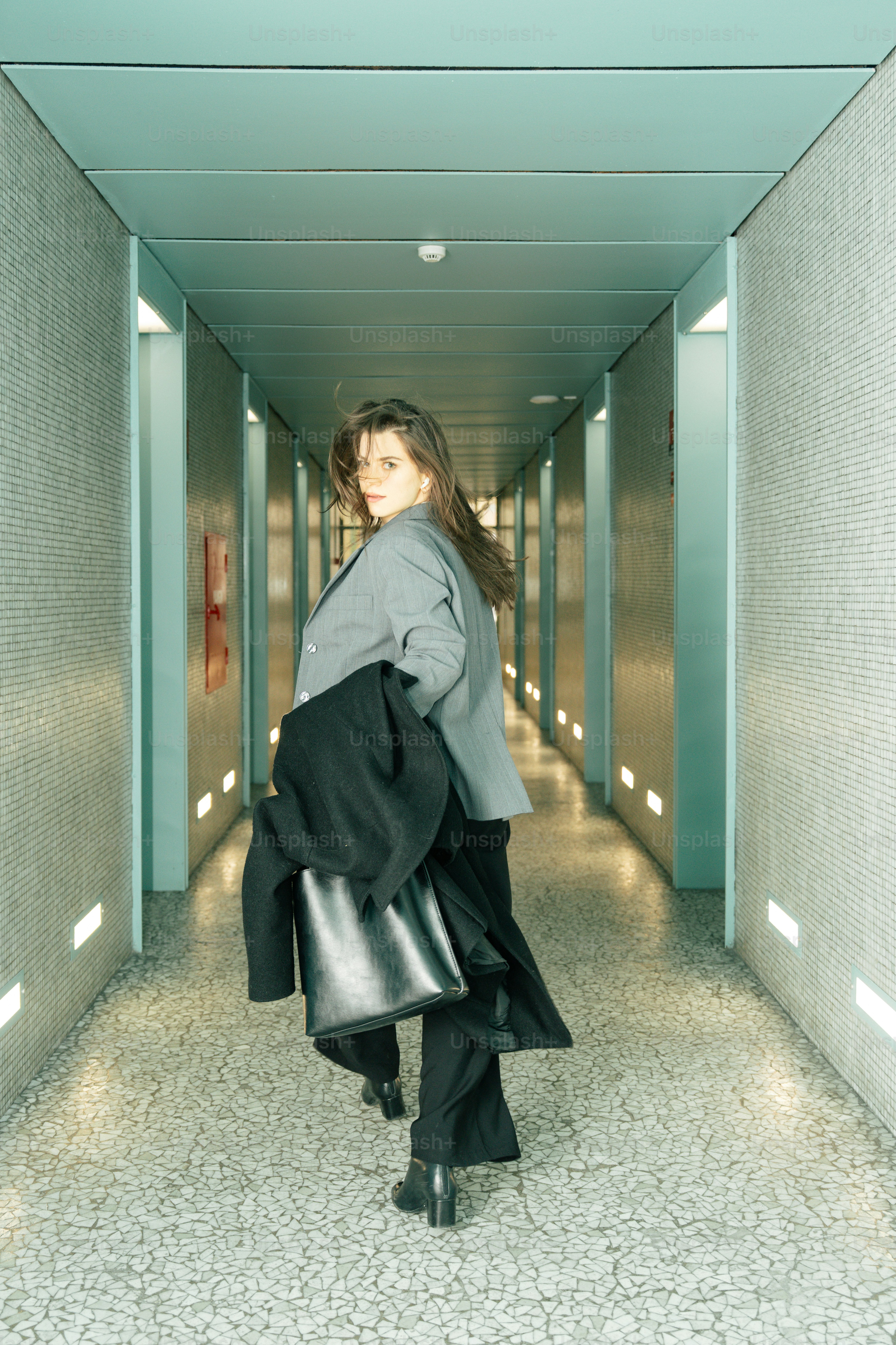 Woman walking down a modern hallway with lights
