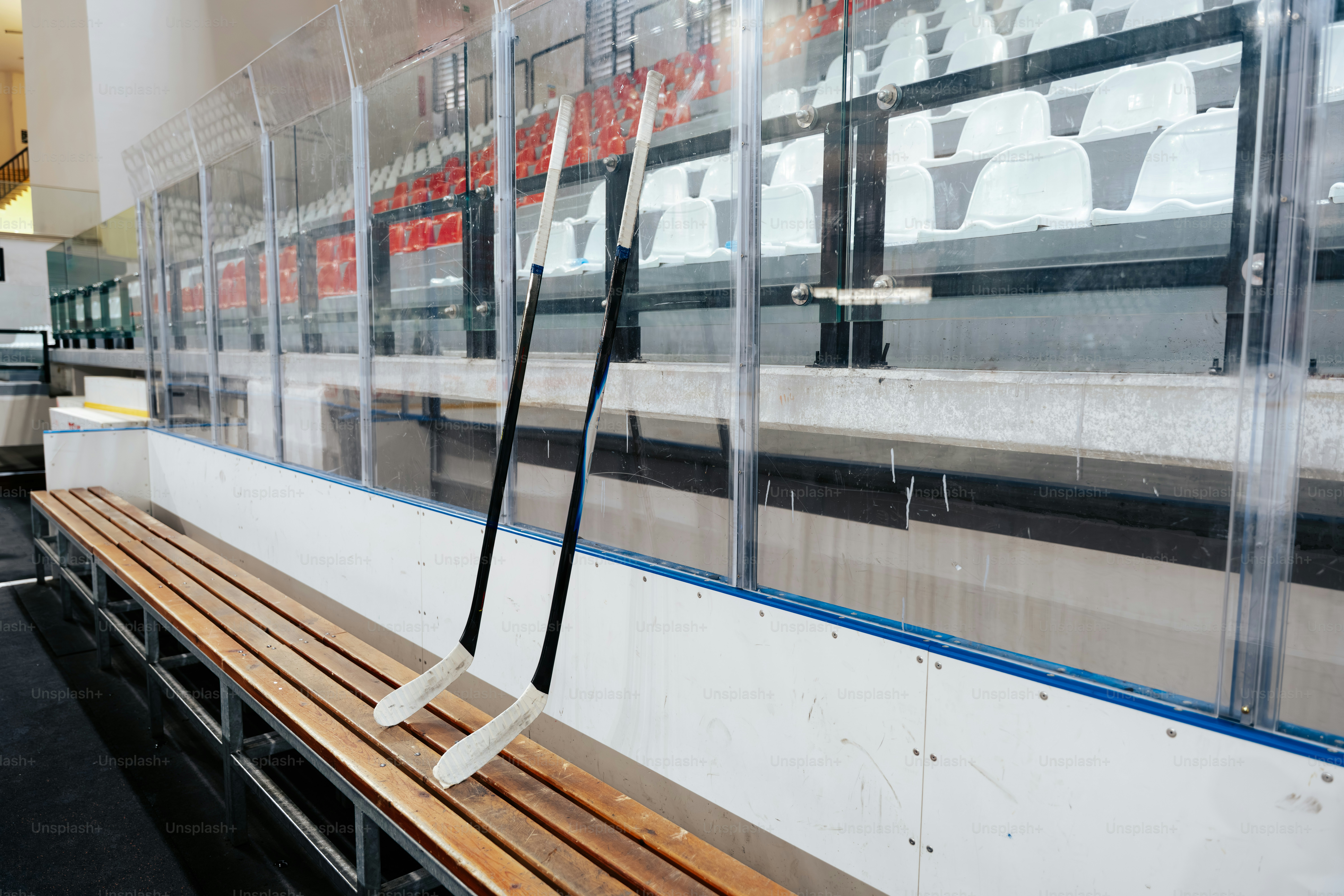 얼음 근처 벤치 위에 하키 스틱 두 개가 놓여 있다.