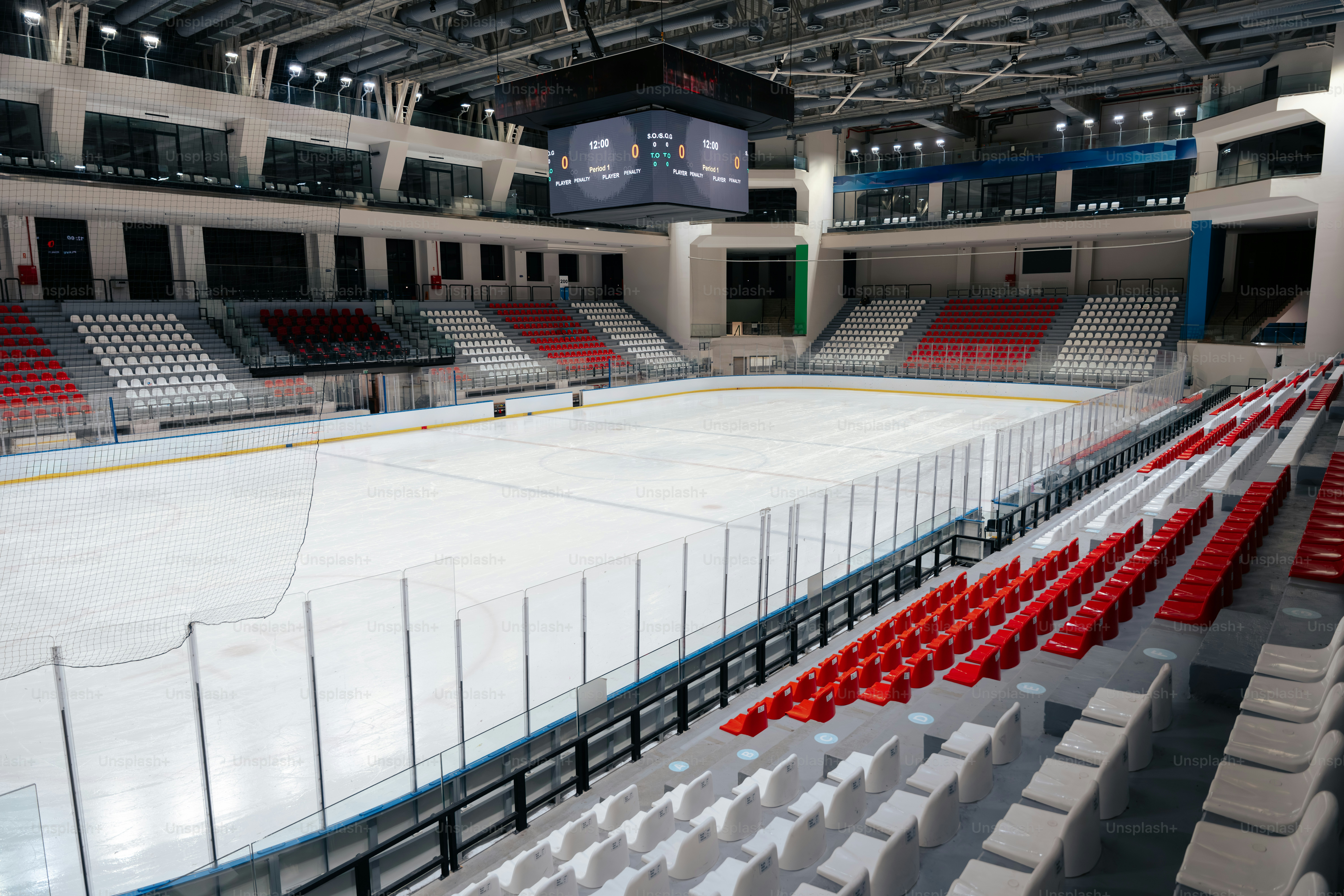 Empty ice hockey arena with red and white seats